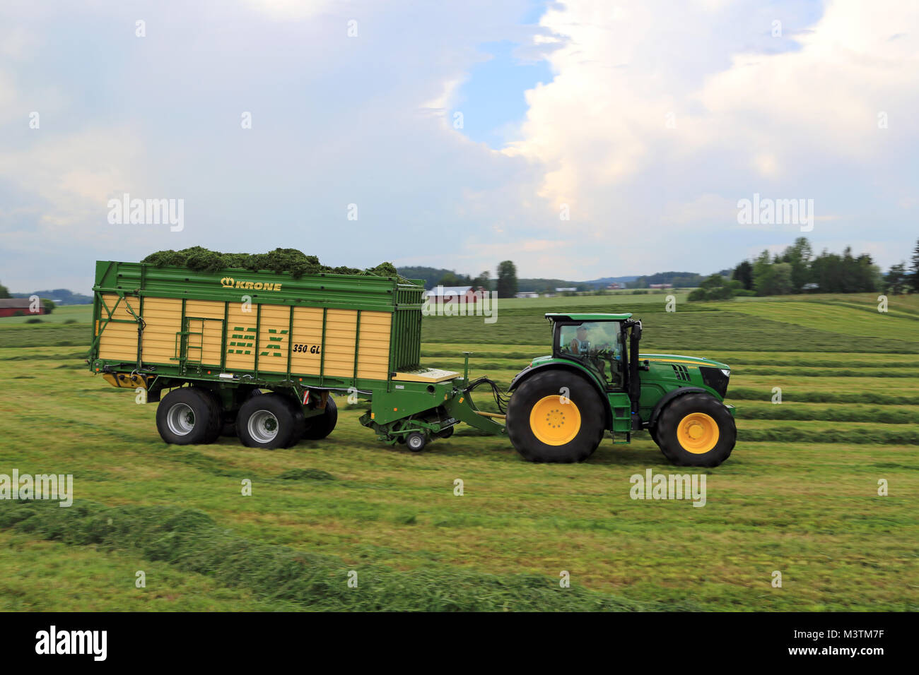 Mariehamn, Finnland - 20. JULI 2014: John Deere 6210R Traktor- und Krone MX350 GL Futter und Wagen sammeln Silage Entlastung. Verwendung von Wagen anstelle von Tr Stockfoto