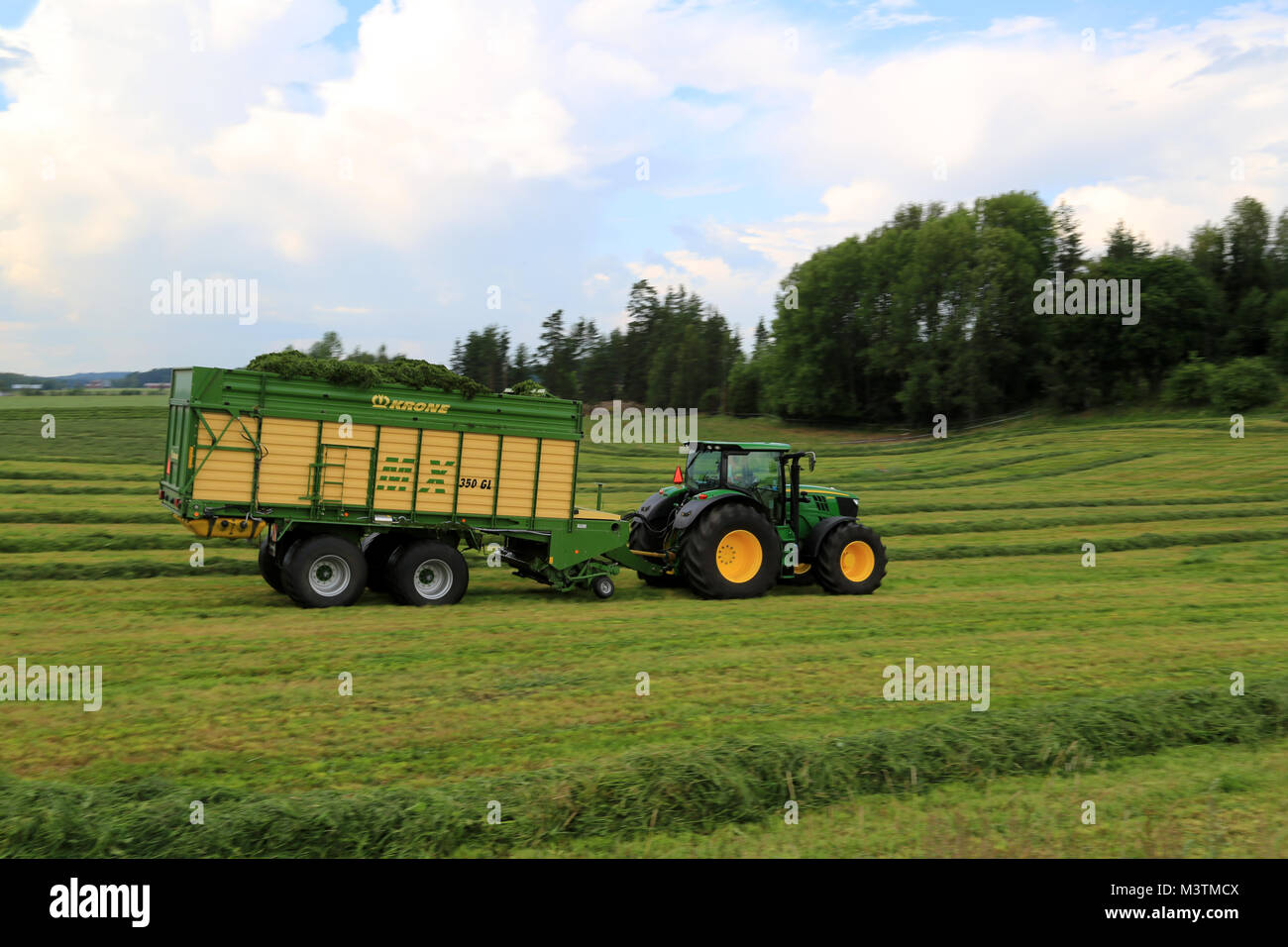Mariehamn, Finnland - 20. JULI 2014: John Deere 6210R Traktor mit Krone MX350 GL & Silierwagen Transporte gemähtem Heu. Der Wagen bietet erhebliche Vorteile Stockfoto