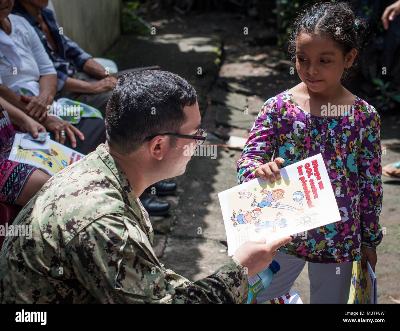 Cuscatlan, El Salvador (Sep. 2, 2016) - Lt Alister Bryson, Entomologe, um die marine Umwelt der präventiven Medizin Einheit 2, zugeordnet, gibt ein Kind ein Malbuch zu einem temporären Versorgung Website in Cuscatlan, El Salvador während der südlichen Partnerschaft Station 2016 (SPS 16). SPS 16 ist eine jährliche Serie der U.S. Navy Bereitstellungen auf Experte Austausch mit Partner Nation, Militär und Sicherheitskräfte in Zentral- und Südamerika und der Karibik. Us-Militär Teams arbeiten mit Partner nation Kräfte während der Naval-Schulungsübungen, militärischen Engagements und Co Stockfoto