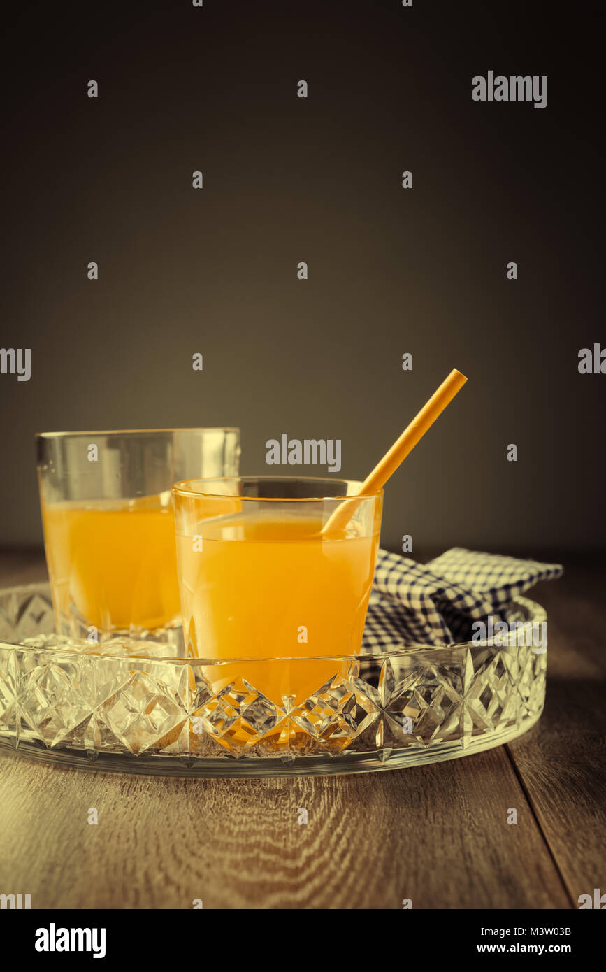 Glas Gläser Orangensaft auf Glas Fach mit einem Tuch Stockfoto