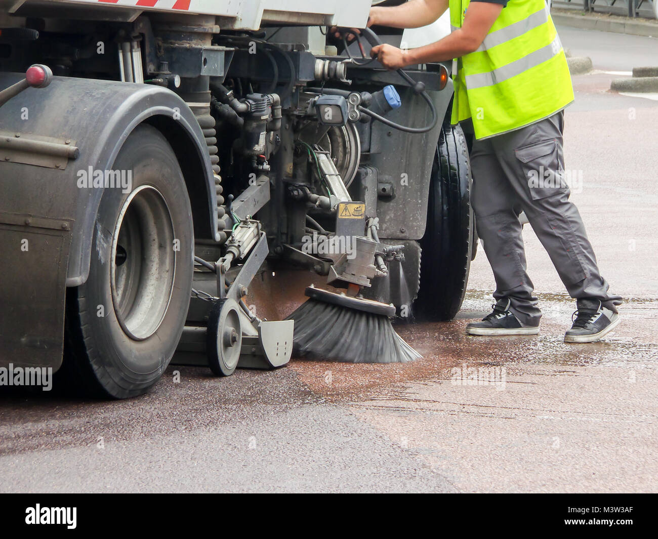 Arbeitnehmer mit einem LKW-Reinigung einer Straße Stockfoto