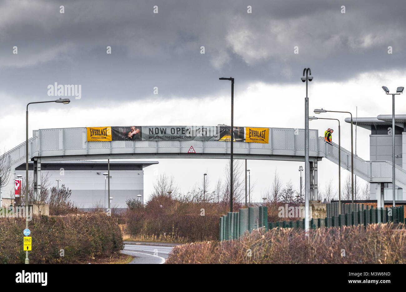 Zwei männliche workres Überqueren einer Metall Fuß Brücke auf Sport Direct Distribution Warehouse an Shirebrook, Derbyshire. Stockfoto