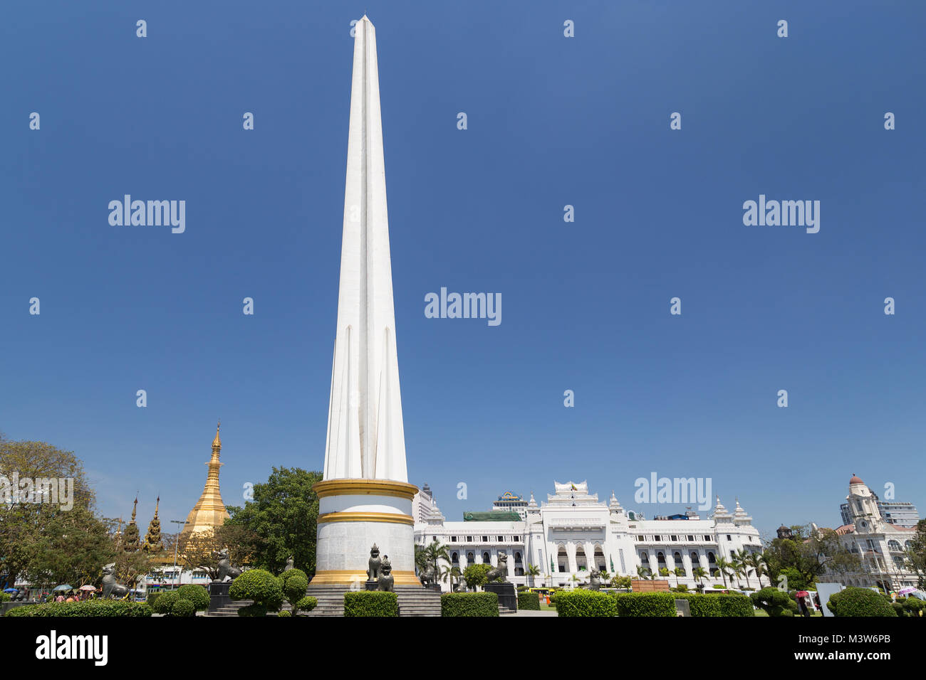 Independence Monument an der Maha Bandula Park an einem sonnigen Tag in der Innenstadt von Yangon, Myanmar. Sule Pagode und Yangon City Hall sind im Hintergrund. Stockfoto