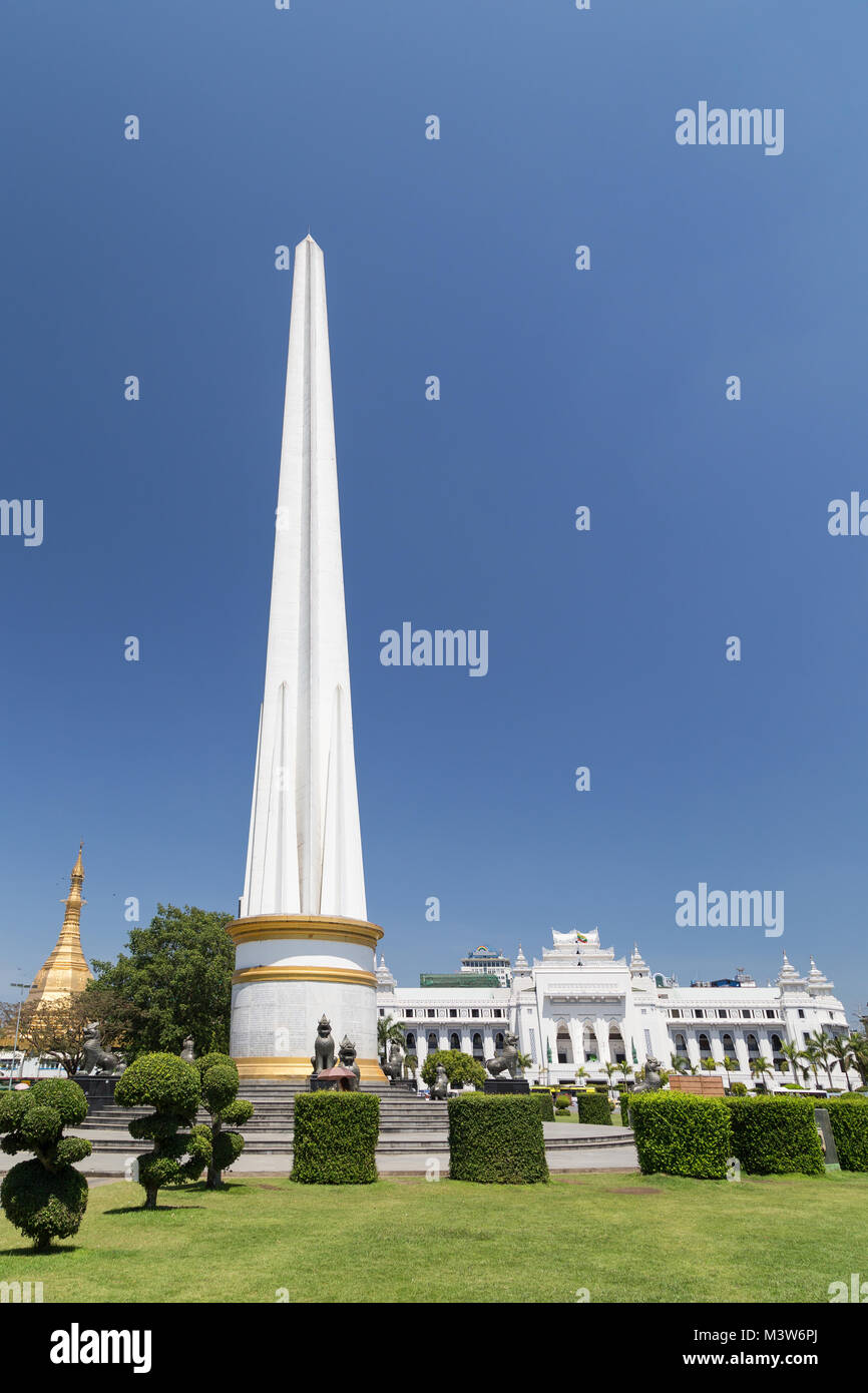 Independence Monument an der Maha Bandula Park an einem sonnigen Tag in der Innenstadt von Yangon, Myanmar. Sule Pagode und Yangon City Hall sind im Hintergrund. Stockfoto