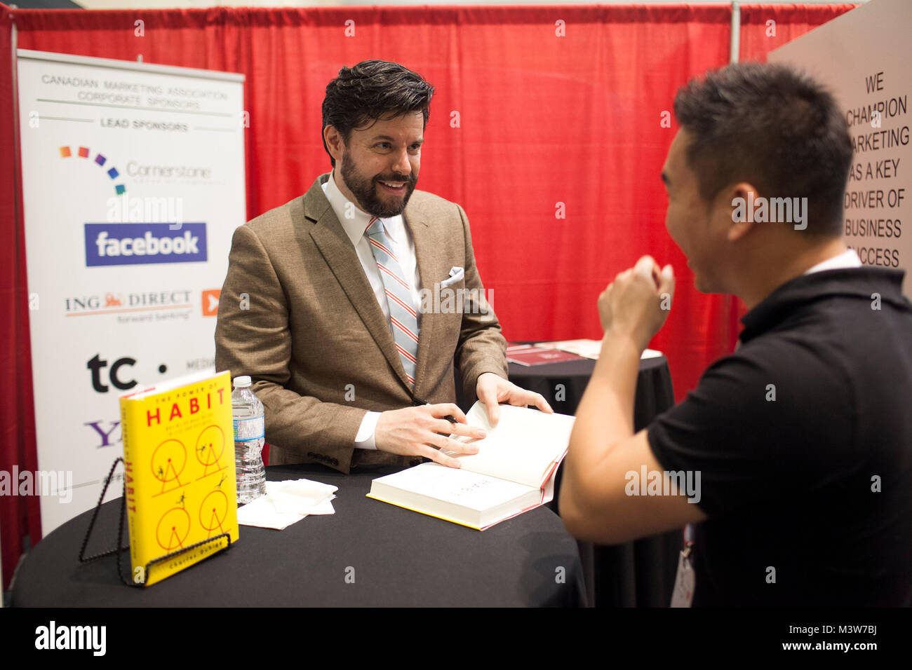Autor Charles Duhigg unterzeichnet Bücher während einer Pause in der Kunst des Marketings Konferenz in Toronto, Ontario, Kanada am Mittwoch, Juni 05, 2013. Die Konferenz Referenten und Lieferanten auf das neue Zeitalter des Marketing ausgerichtet, darunter Hauptredner Biz Stone, Gründer und Creative Director von Twitter. Stockfoto