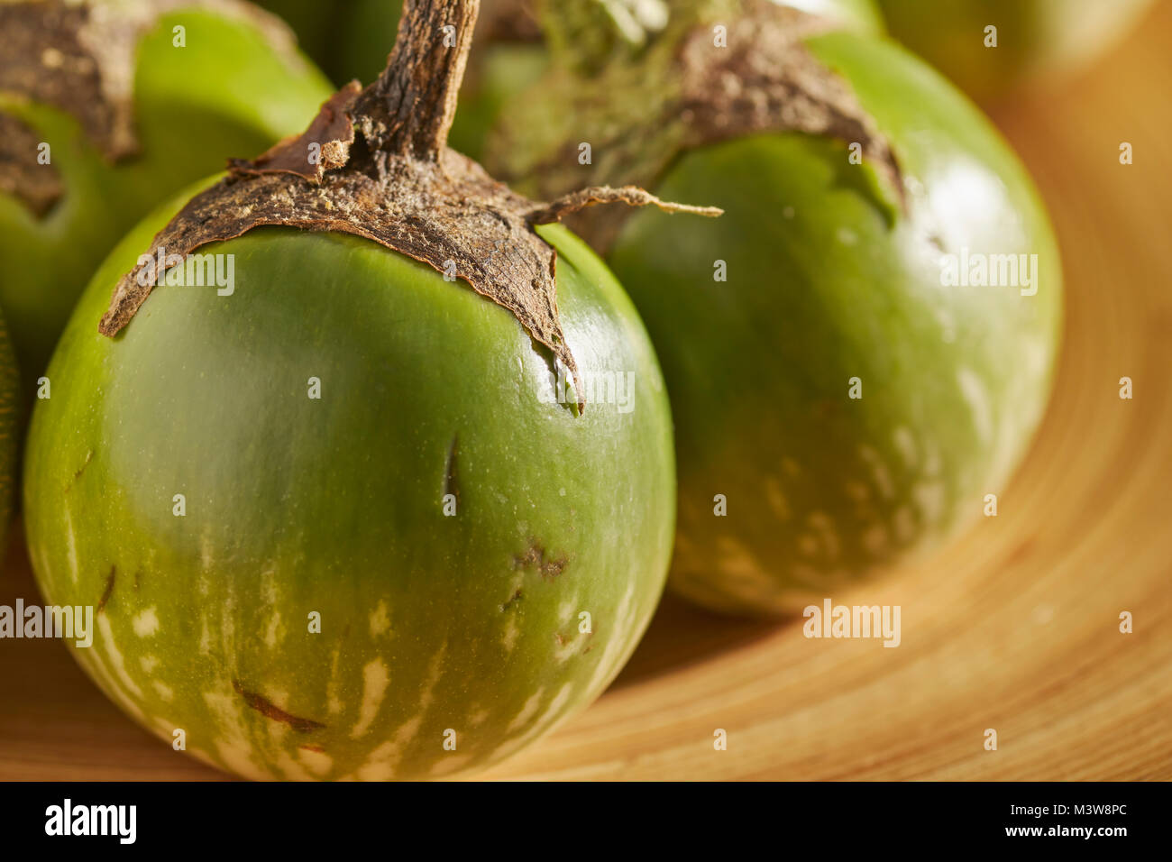 Ganze, frische, rohe Thailändisches Grünes Auberginen, manchmal auch 'Thai Auberginen' Stockfoto