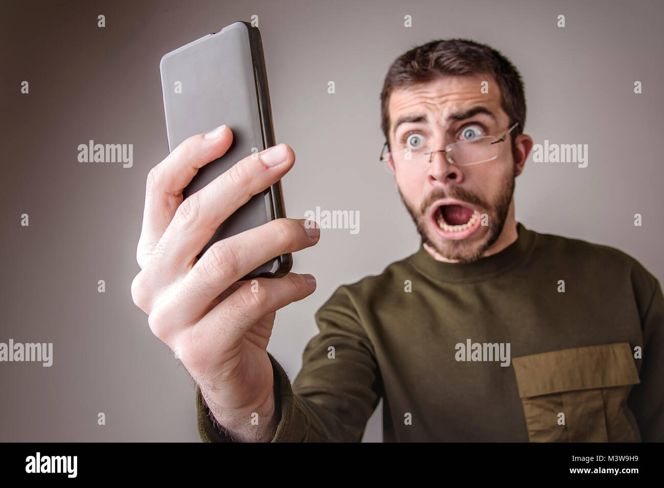 Wütende Mann bei seinem Telefon schreien Stockfoto