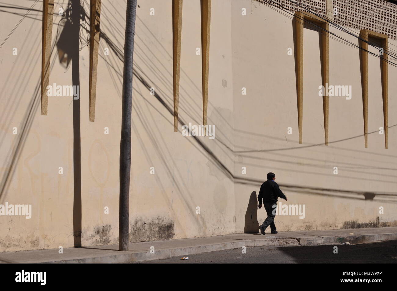 Ein fussgänger vor einem gelben Wand auf der Straße in Sucre, Bolivien Stockfoto