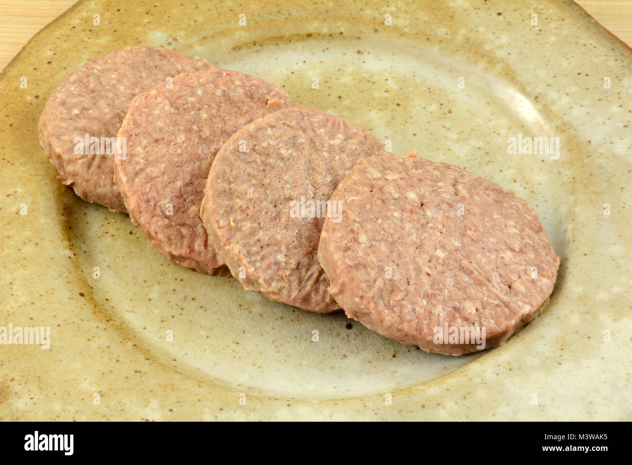 Frozen raw Hamburger Pastetchen Auftauen auf Keramik Platte wie Grillen Vorbereitung Stockfoto