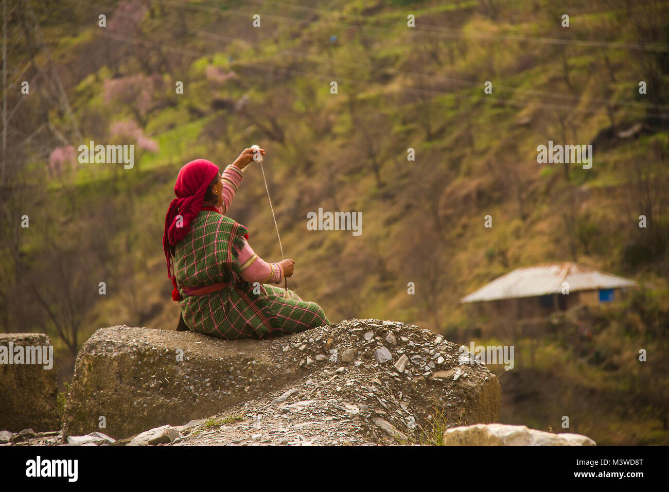 Eine Frau spinnendes Garn in einem Dorf im Himalaya Stockfoto