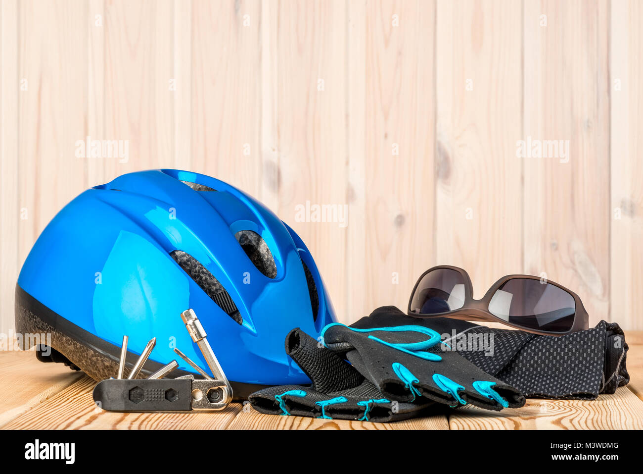 Helm, Handschuhe und Radfahren Zubehör auf einem hölzernen Hintergrund Stockfoto