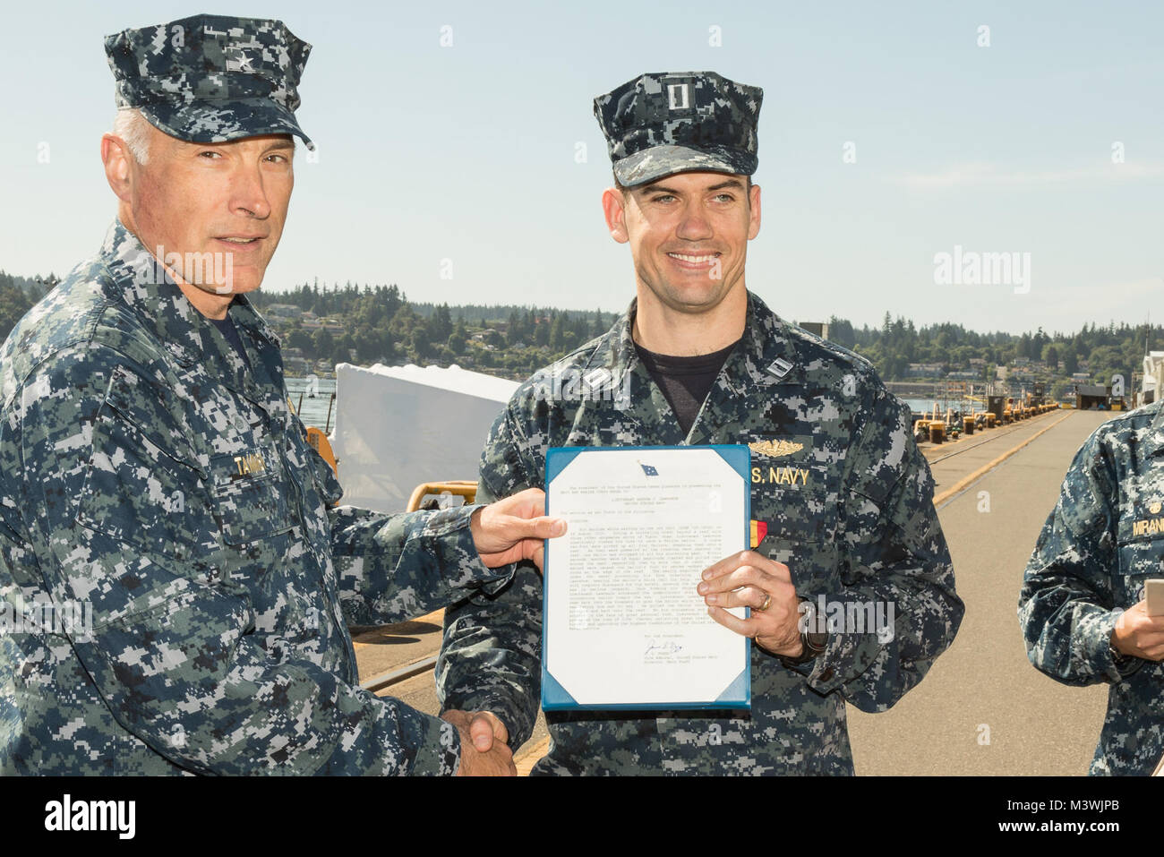 BREMERTON, Washington (30. Juni 2017) - Hintere Adm. John Tammen, Commander, U-Boot Gruppe 9, präsentiert Lt Andrew Lawrence, der Gold Crew der Atom-U-Boot USS Ohio zugeordnet (SSGN 726), mit der Navy und Marine Corps Medaille bei einer Preisverleihung im Puget Sound Naval Shipyard und Intermediate Maintenance Facility. Lawrence erhielt die Auszeichnung für das Leben seines shipmate gespart, als er fast bei einem Schnorchelausflug ertrank das Boot im Hafen Apra, Guam festgemacht wurde. (U.S. Marine Foto von Jeremy Moore/Freigegeben) 170630-N-QS 832-001 von Naval Base Kitsap (NBK) Stockfoto