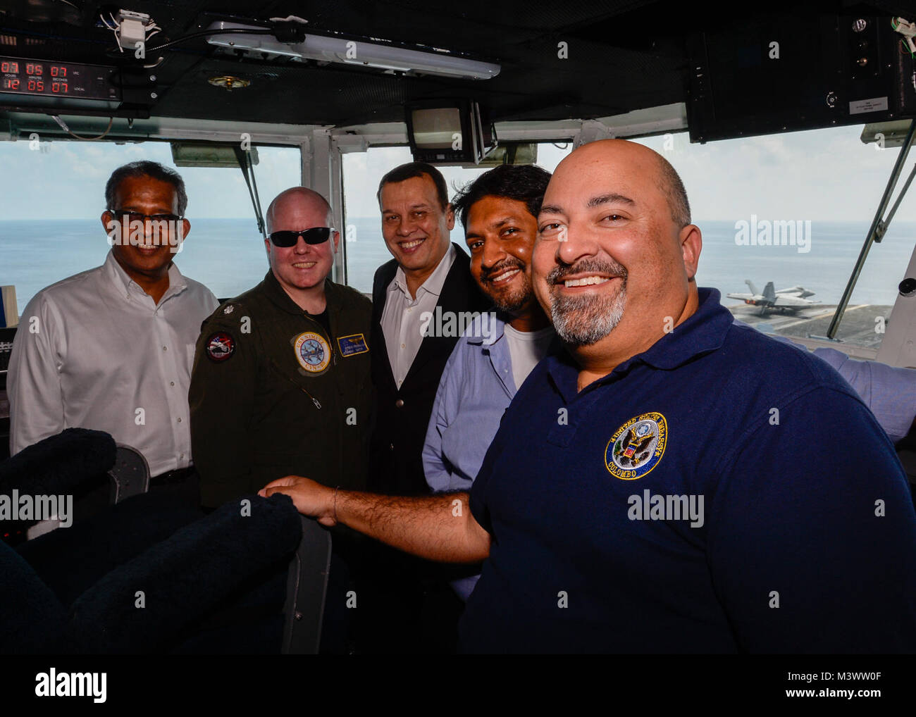 Arabische Meer (Okt. 2010) 27, 2017) US-Botschafter in Sri Lanka und den Malediven Atul Keshap, Links, posiert für ein Foto mit U.S. Navy Cmdr. Steve Froelich, Navigator des Schiffes, der zweite von links, und Sri Lankan Eingeborenen auf der Brücke der Flugzeugträger USS Nimitz (CVN 68), 27.10.2017, in den Persischen Golf. Der Nimitz Carrier Strike Group ist auf einem regelmäßigen Einsatz in der Siebten Flotte der Verantwortung zur Unterstützung der Maritime Security Operations und Theater Sicherheit Bemühungen um Zusammenarbeit. (U.S. Marine Foto von Mass Communication Specialist Seaman David Claypool)171027-N-XU 691-087 von Nav Stockfoto