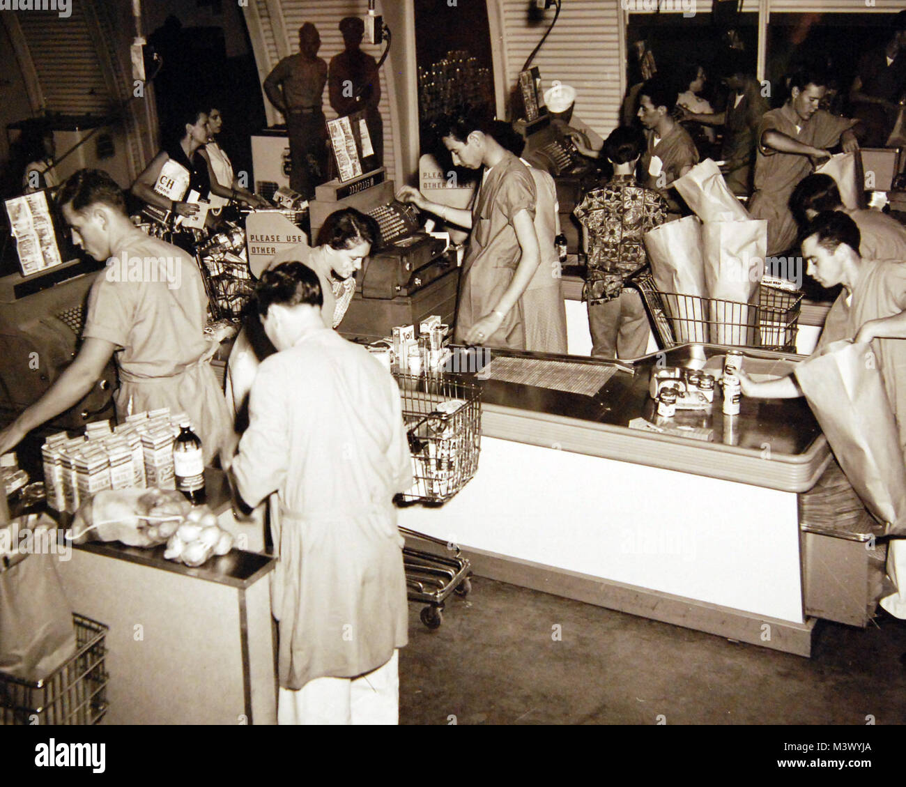 80-G--680519: Wiedereröffnung des Volkskommissars Store an der Naval Air Station Friseure, Hawaii, 2. August 1955. Scharen von begeisterten Menschen halten cashers beschäftigt. Offizielle U.S. Navy Foto, jetzt in den Sammlungen der National Archives. (2018/01/17). 80-G--680519 24879366757 o Stockfoto