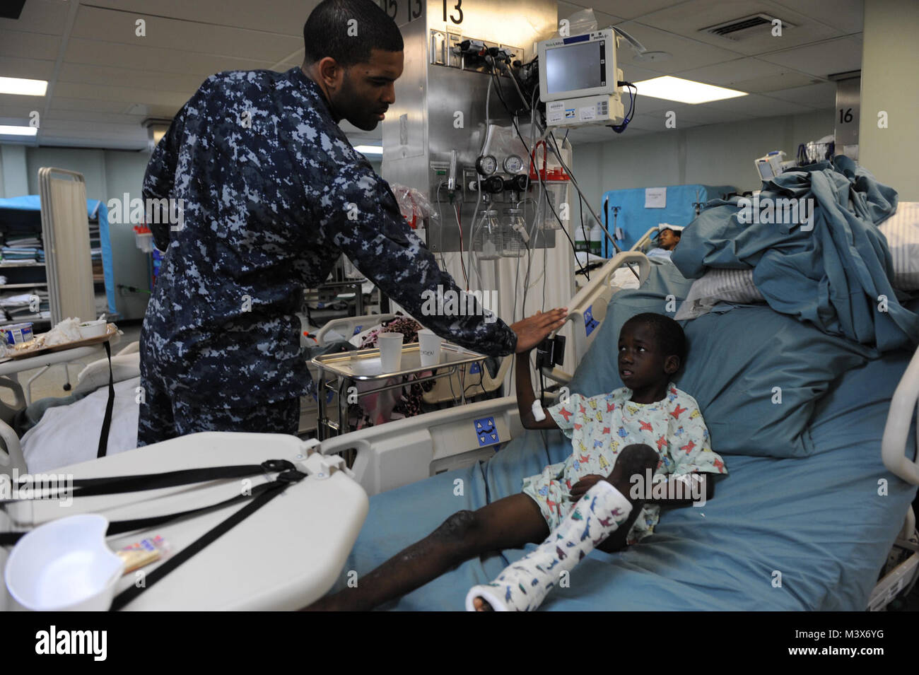 110417-F-NJ 219-320 KINGSTON, Jamaika (17. April 2011) Hospital Corpsman 3. Klasse Lamonte Hammond, aus Md., hi-fives Eine jamaikanische Junge nach seiner physikalischen Therapie Behandlung an Bord der Military Sealift Command Hospital Ship USNS Comfort (T-AH 20) im Verlauf der weiteren Versprechen 2011 (CP 11). CP11 ist ein 5-Monat humanitäre Mission zur Unterstützung der Karibik, Zentral- und Südamerika. (U.S. Air Force Foto: Staff Sgt. Courtney Richardson/Freigegeben) Weiterhin Versprechen 2011 in Jamaika durch ussouthcom Stockfoto