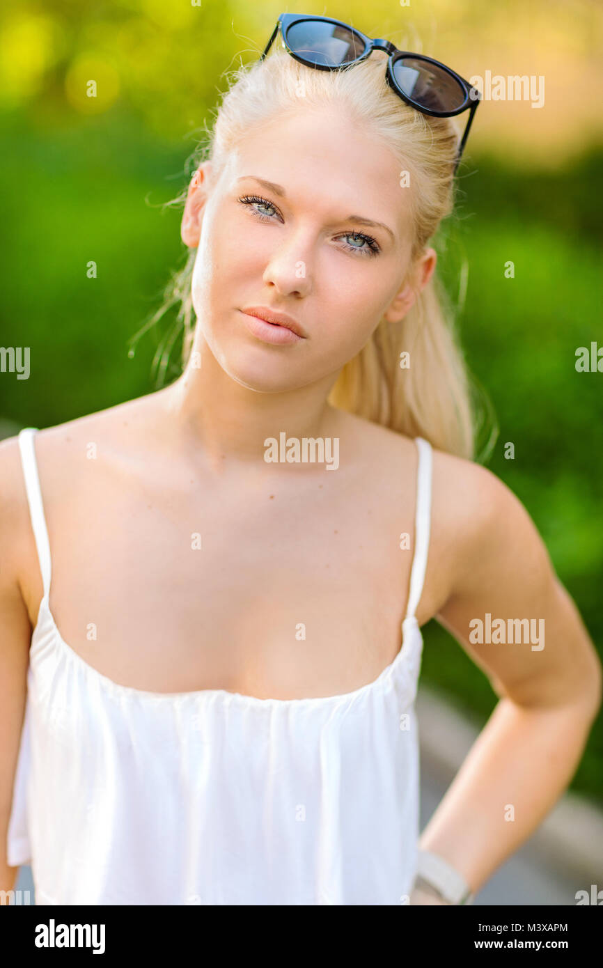 Natürliche Blondine jugendlich Mädchen steht auf der Straße in der Sonne Stockfoto