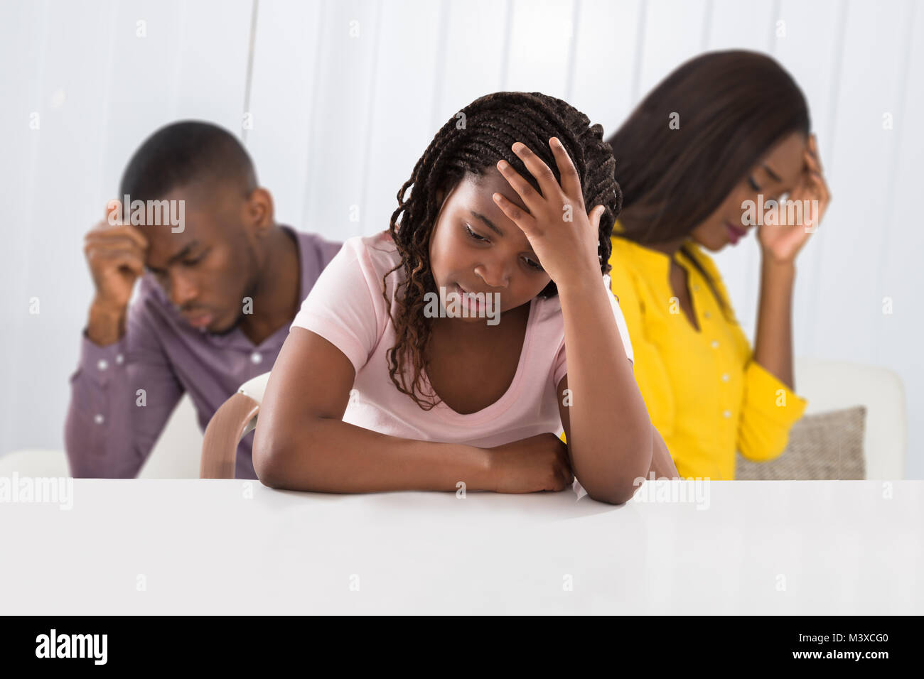 Eltern sitzen auf dem Sofa streiten Lautstark hinter Mädchen für Ihre Ohren Stockfoto