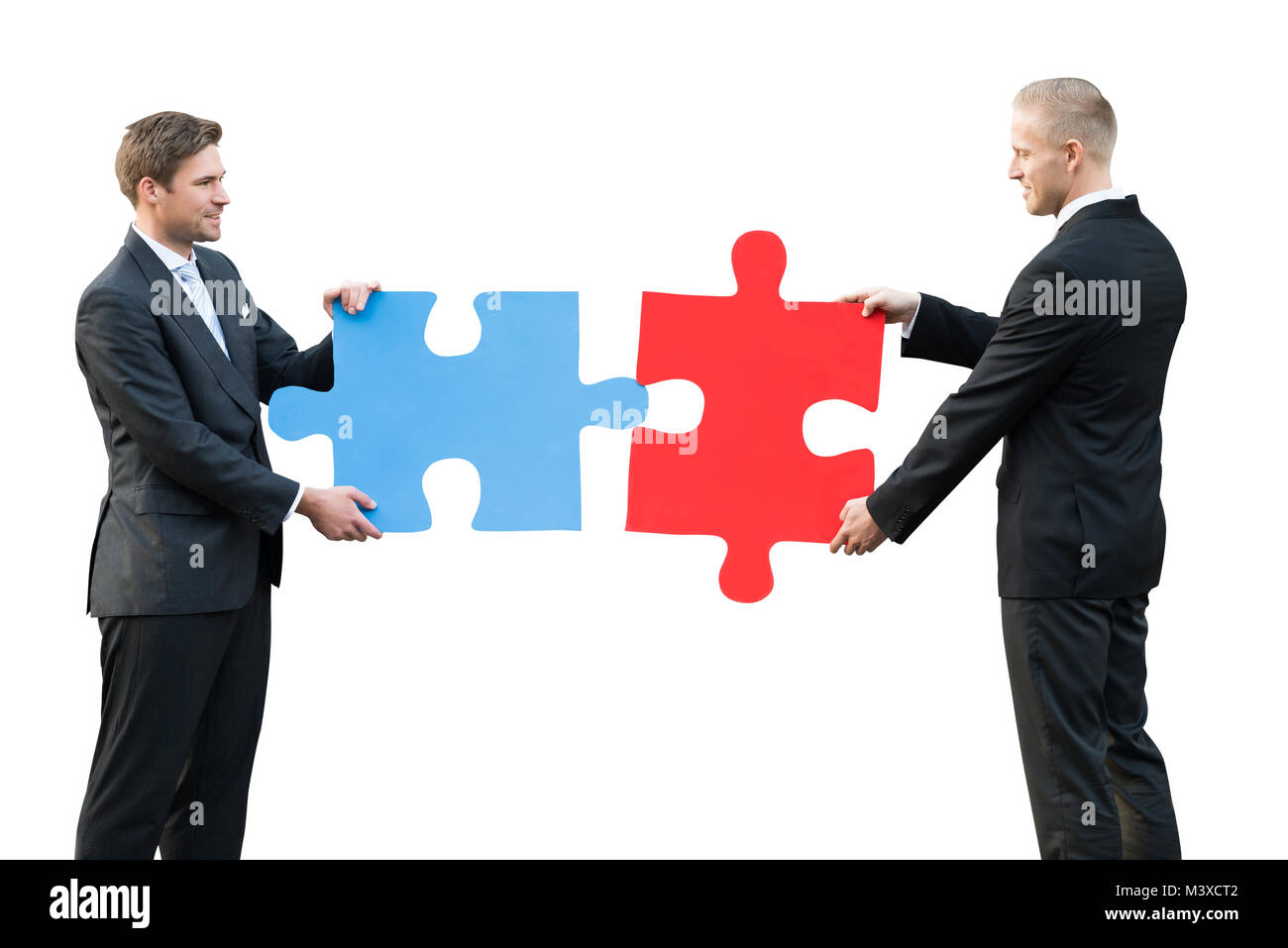 Seitliche Sicht auf zwei Geschäftsleute Holding Blau und Rot gefärbte Puzzle auf weißem Hintergrund Stockfoto