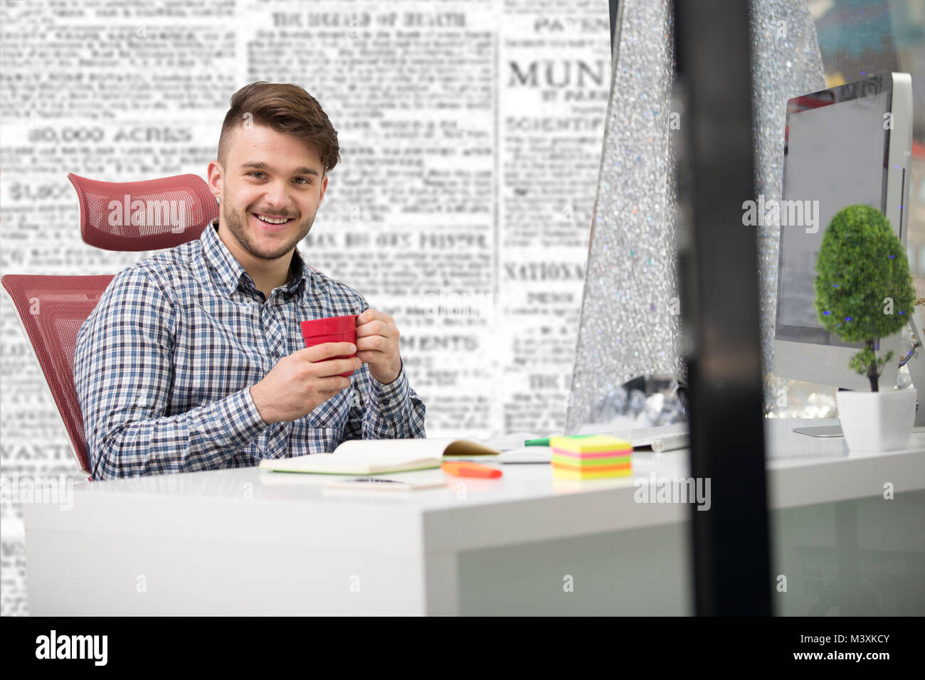 Hübscher junger Mann bei der Arbeit mit Laptop im Büro Stockfoto