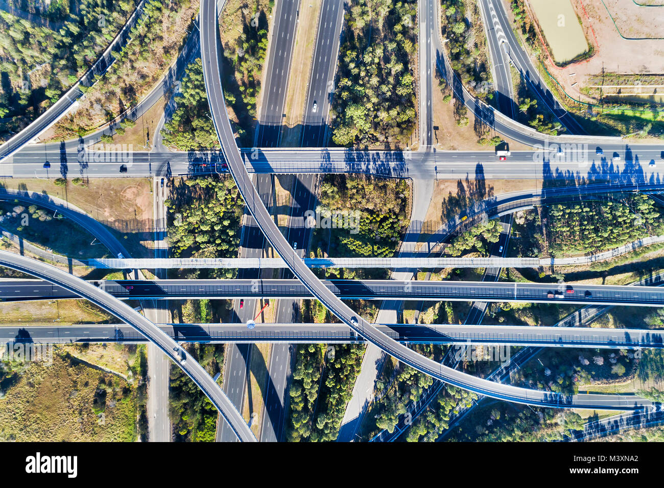 Luftbild von Oben nach Unten Blick auf massive multi-level Austausch auf Sydneys Autobahn 4 und Autobahn 7 an einem sonnigen Sommertag mit Licht Verkehr Stockfoto