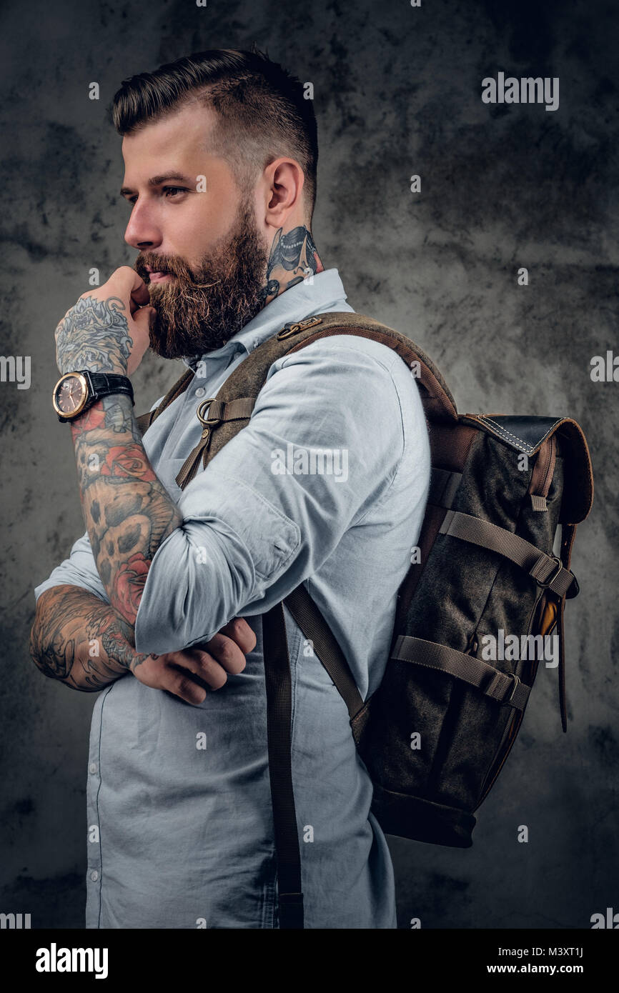 Ein Mann mit Tattoos auf seine Arme und Hals mit Rucksack auf seinem Bac Stockfoto