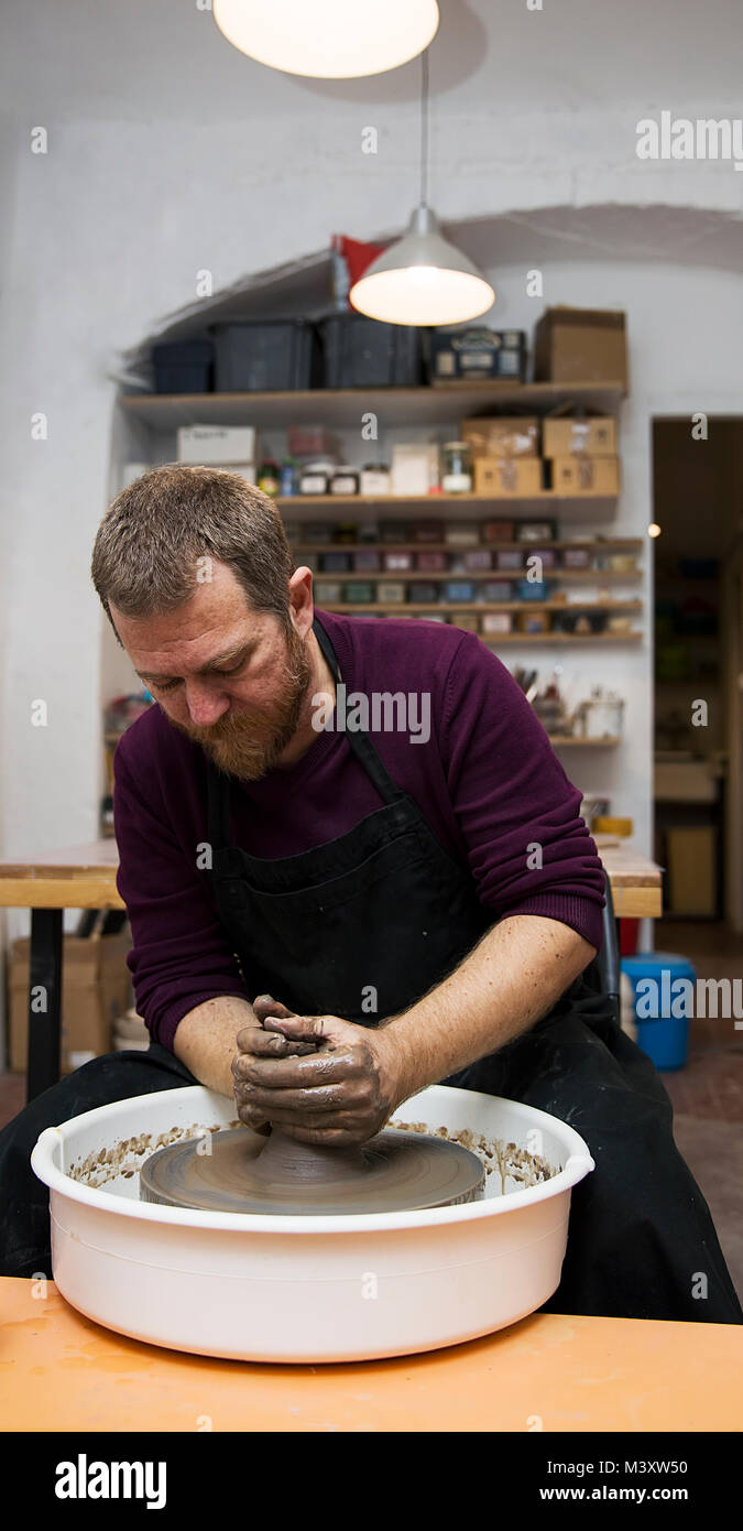 Blick auf ein Künstler macht Ton auf einem Drehrad in der Werkstatt Stockfoto