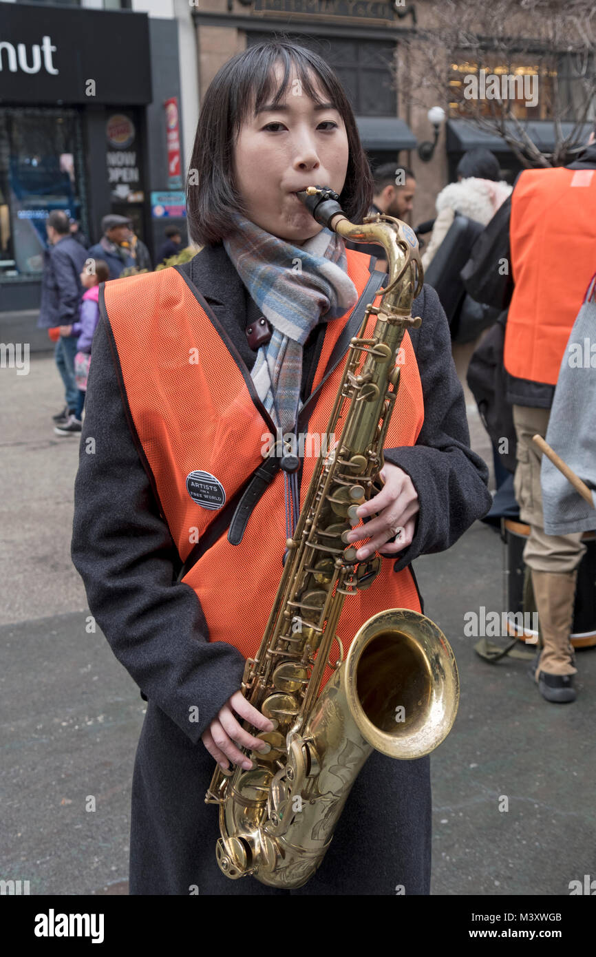 Eine hübsche Japanische Saxophonist aus der Aktivist band Künstler für eine freie Welt. An einem pro Einwanderung Rallye in Herlad Square, New Yrok Stadt. Stockfoto