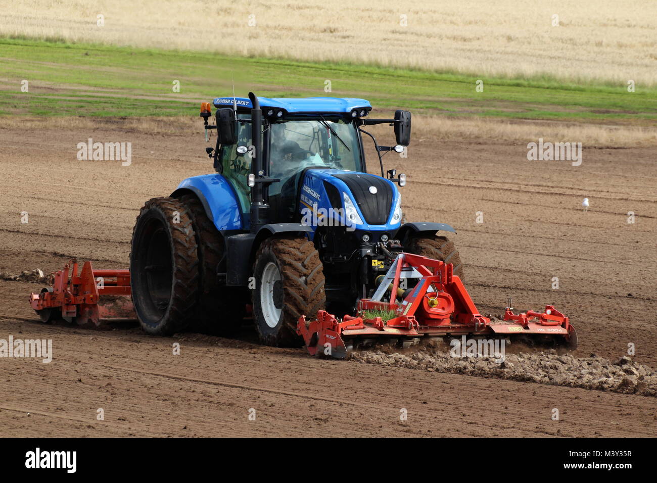 Ein New Holland T 7.245 Traktor betrieben von Hamish Gilbert, der Vorbereitung an der West Kilbride in Ayrshire. Stockfoto