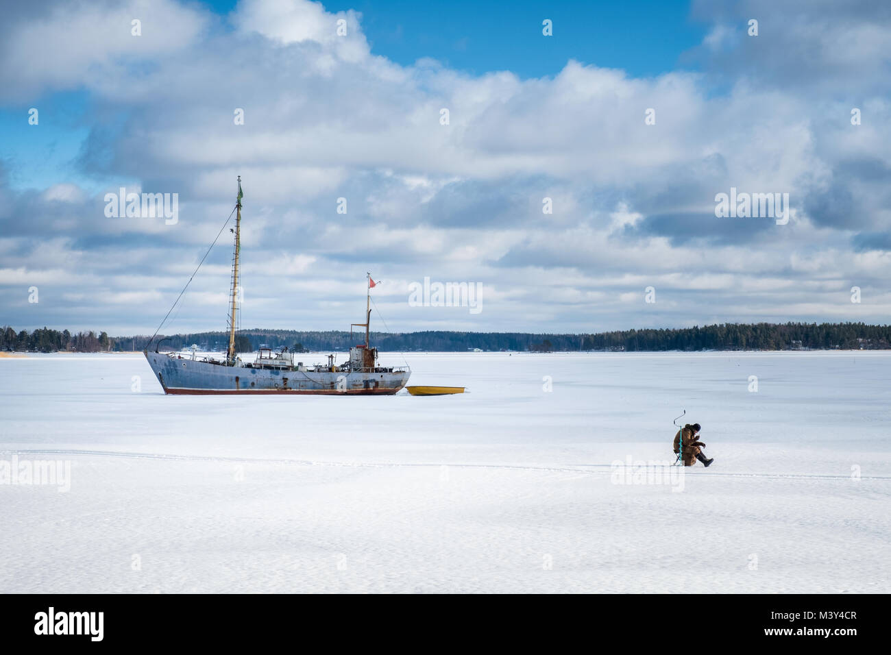 Porvoo, Finnland - 24. Februar 2017: Fischer sitzen und Eisangeln im Winter Tag in Finnland Stockfoto