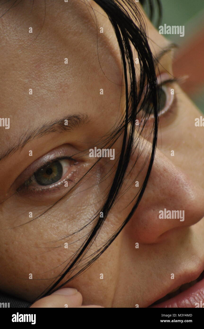 Die Frau unterhalten und nachdenklich. Mädchen mit Ohrringe. Lächeln und Zufriedenheit. Stockfoto