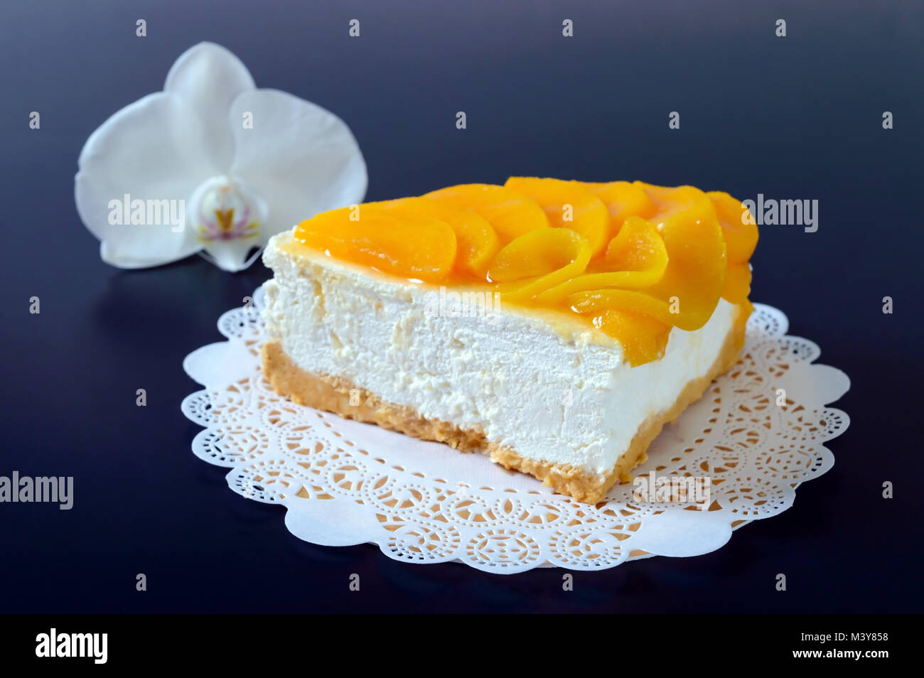 Zarte souffle mit saftigen Pfirsiche. Ein leckeres Stück Kuchen auf einem goldenen stehen auf einem schwarzen Hintergrund. Stockfoto