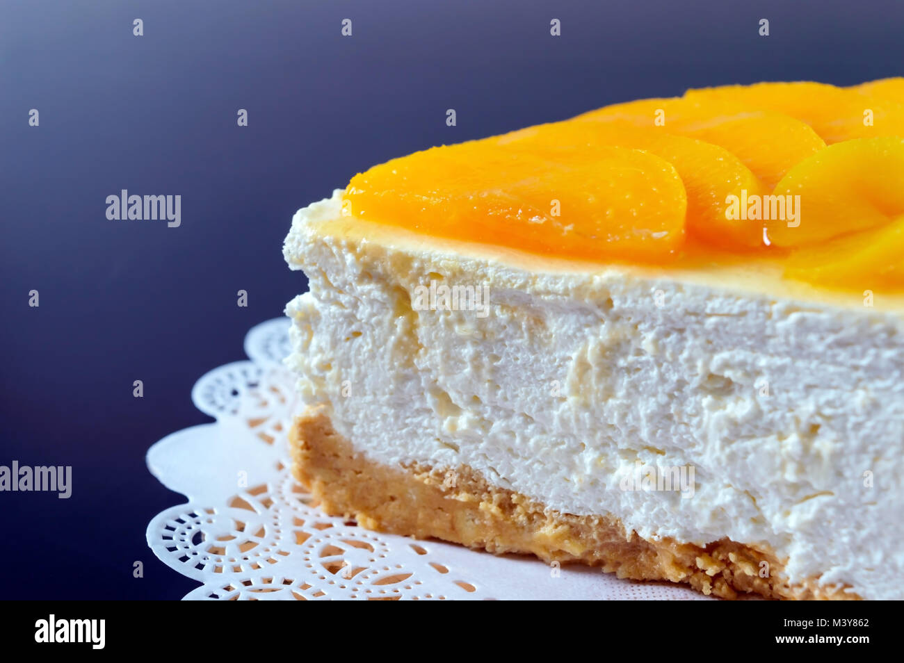 Zarte souffle mit saftigen Pfirsiche. Ein leckeres Stück Kuchen auf einem goldenen stehen auf einem schwarzen Hintergrund. Stockfoto