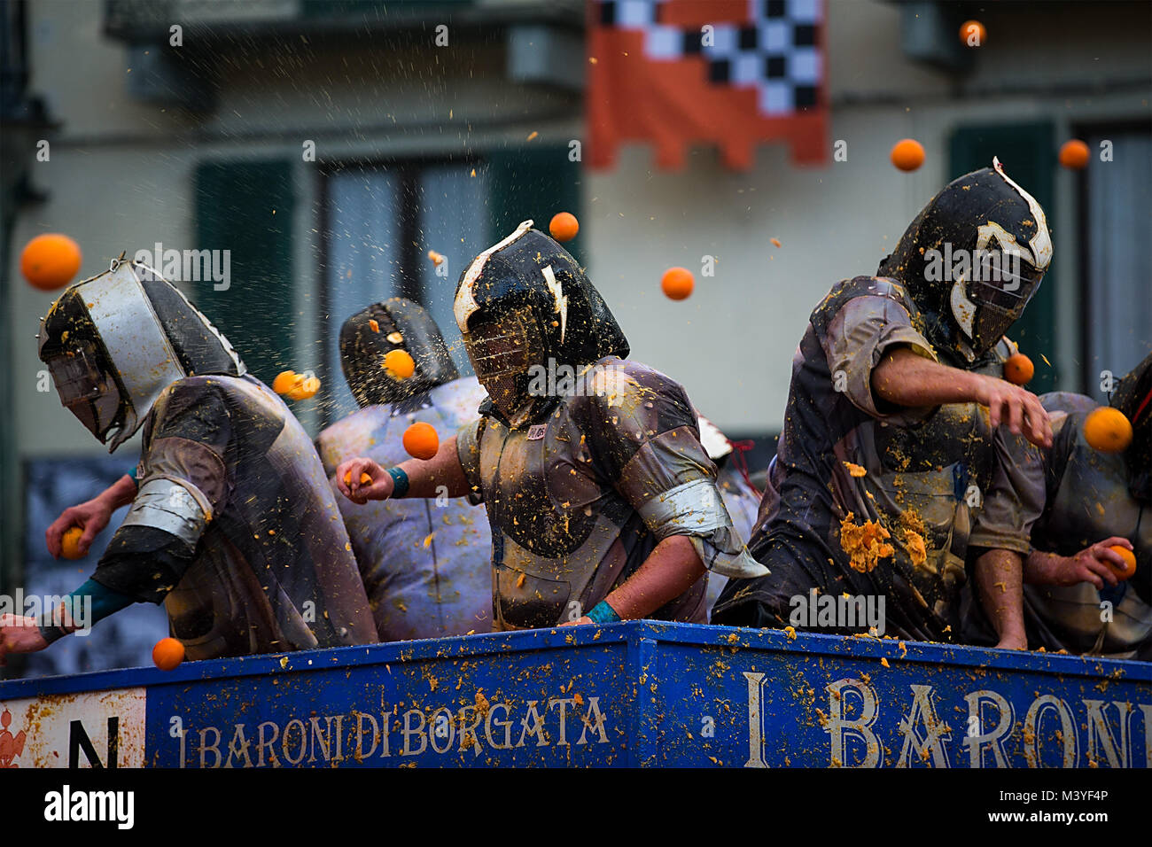 Ivrea, Italien. 12 Feb, 2018. Mitglieder eines Teams kämpfen mit Apfelsinen, die während einer jährlichen historischen Karneval "Schlacht der Apfelsinen" in der norditalienischen Stadt Ivrea, Italien, am 12.02.2018. Credit: Jin Yu/Xinhua/Alamy leben Nachrichten Stockfoto