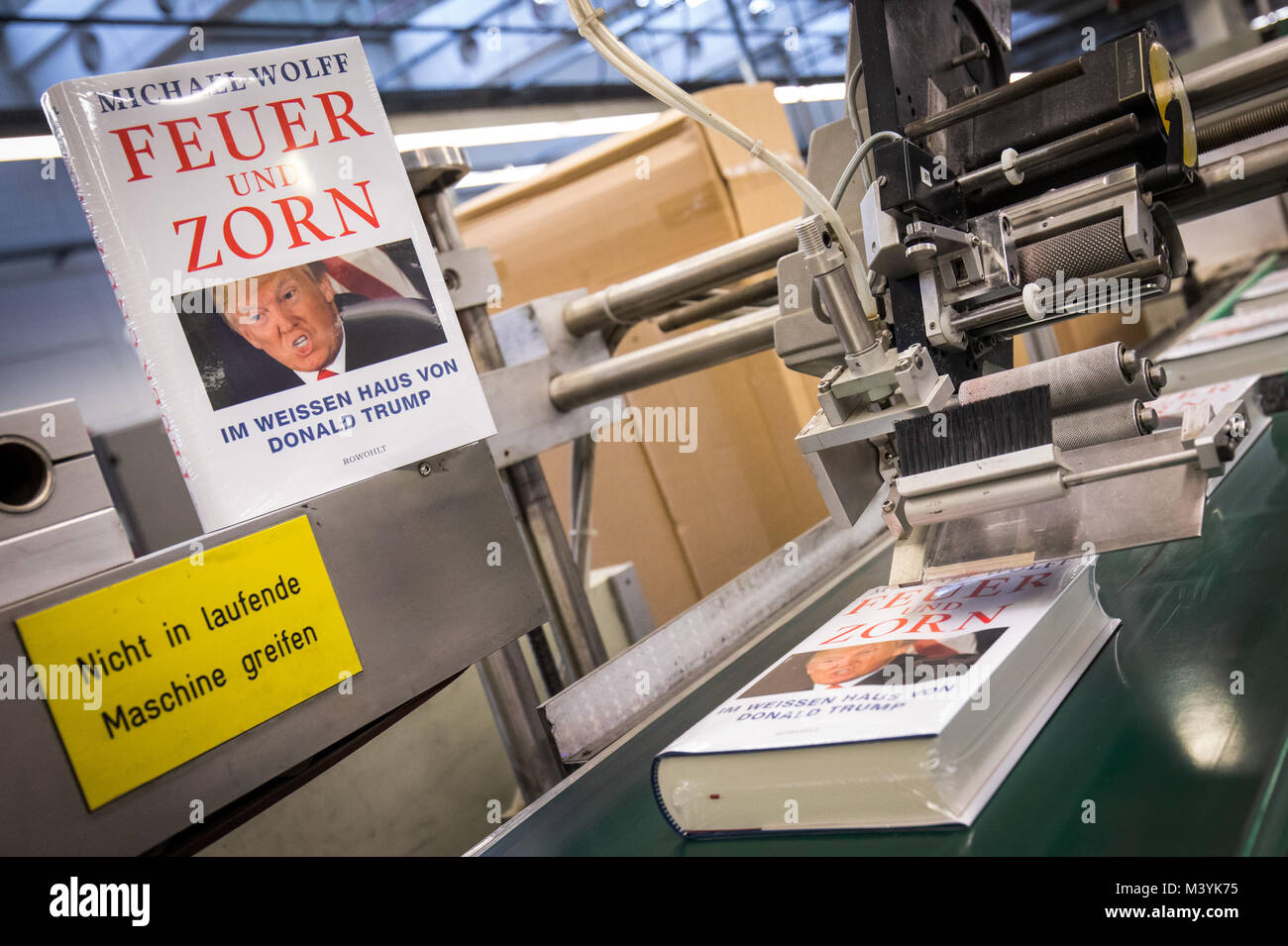 Achtung: Embargo für die Veröffentlichung bis zum 14. Februar 00:00 Uhr GMT! - Frisch gedruckt und verpackt Ausgaben des Buches "Feuer und Zorn. Im Weissen Haus von Donald Trump', die deutsche Ausgabe von "Feuer und Wut. Im Inneren des Trump White House', auf einem Förderband während einer Presse Tour am CPI Clausen & Bosse Druckerei in Lübeck, Deutschland, 09. Februar 2018 ausführen. Die Offenbarung Buch von M.Wolff über die US-amerikanische Präsident wird von Rowohlt am 16. Februar 2018 veröffentlicht. (Achtung Redaktionen: EMBARGO BIS ZUM 14. FEBRUAR 2018 · 12:00 UHR) Foto: Christian Charisius/dpa Stockfoto