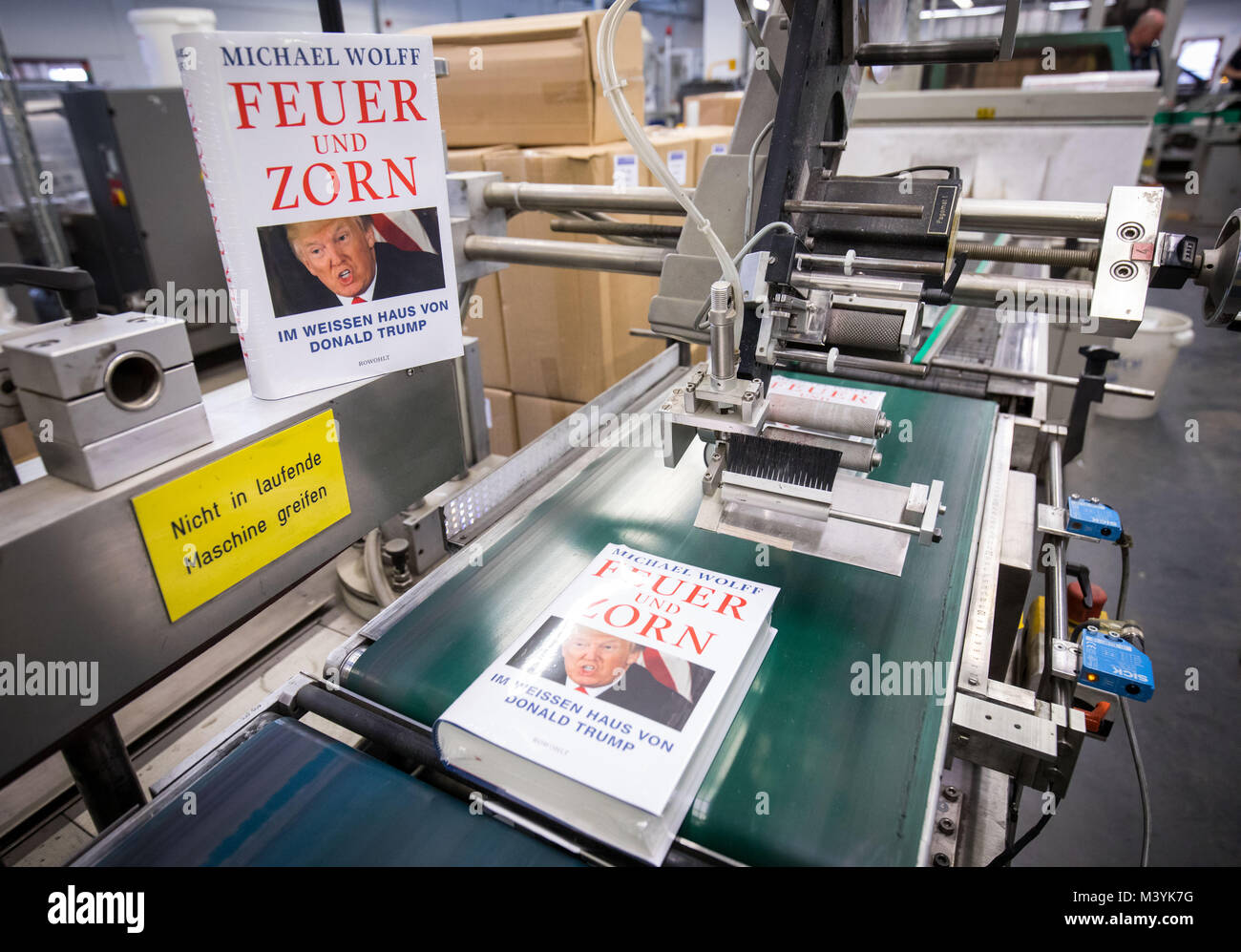 Achtung: Embargo für die Veröffentlichung bis zum 14. Februar 00:00 Uhr GMT! - Frisch gedruckt und verpackt Ausgaben des Buches "Feuer und Zorn. Im Weissen Haus von Donald Trump', die deutsche Ausgabe von "Feuer und Wut. Im Inneren des Trump White House', auf einem Förderband während einer Presse Tour am CPI Clausen & Bosse Druckerei in Lübeck, Deutschland, 09. Februar 2018 ausführen. Die Offenbarung Buch von M.Wolff über die US-amerikanische Präsident wird von Rowohlt am 16. Februar 2018 veröffentlicht. (Achtung Redaktionen: EMBARGO BIS ZUM 14. FEBRUAR 2018 · 12:00 UHR) Foto: Christian Charisius/dpa Stockfoto