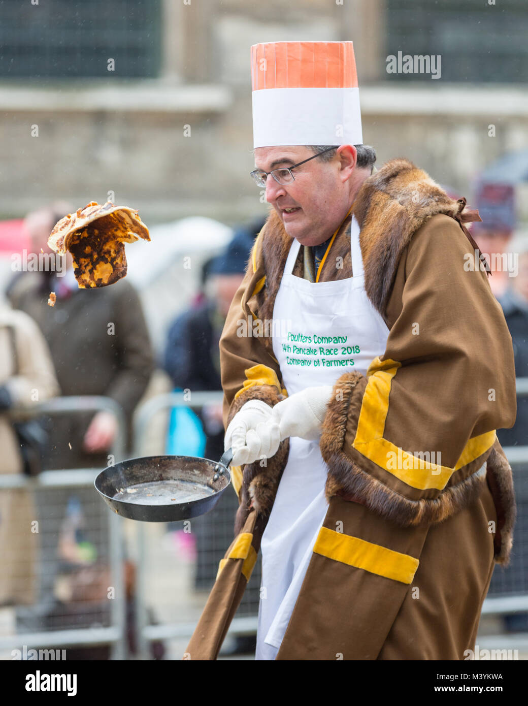 Guildhall Yard, London, 13. Feb 2018. Teilnehmer und Zuschauer viel Spaß bei der jährlichen Inter-Livery Pfannkuchen Rennen am Faschingsdienstag trotz der dürftigen Wetter. Die Stadt Livery Company von Poulters bringt Teams aus der Londoner City livery Unternehmen in irgendeiner Weise zu Pfannkuchen verbunden gezeichnet (die Poulters nehmen Sie die Eier, die Fruiterers die Zitronen und der messerschmiede der Kunststoff Gabel), der Pomp und die Zeremonie, als Konkurrenten Kleid in Ihrem osten Credit: Imageplotter Nachrichten und Sport/Alamy leben Nachrichten Stockfoto