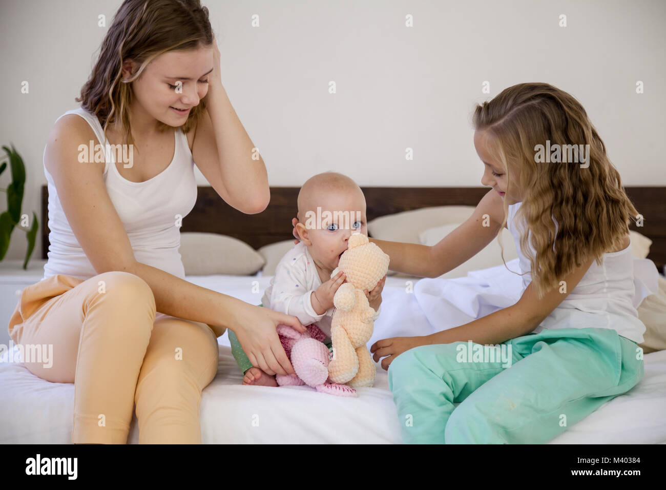Drei Mädchen spielen Schwestern am Morgen im Schlafzimmer Stockfoto