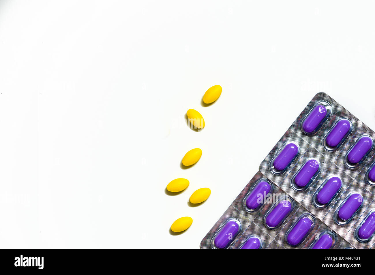 Makroaufnahme der gelbe, ovale Tablette Pillen auf weißem Hintergrund und Lila caplets Pillen in Blisterverpackung. Leichte bis mäßige Schmerzen Management. Schmerzmittel med Stockfoto