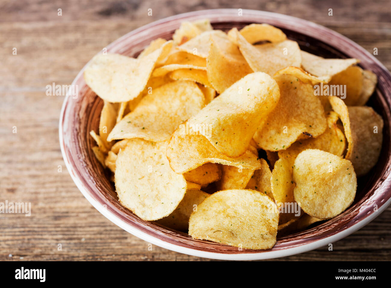 Haufen Kartoffelchips in Schüssel auf Holz- Hintergrund Stockfoto