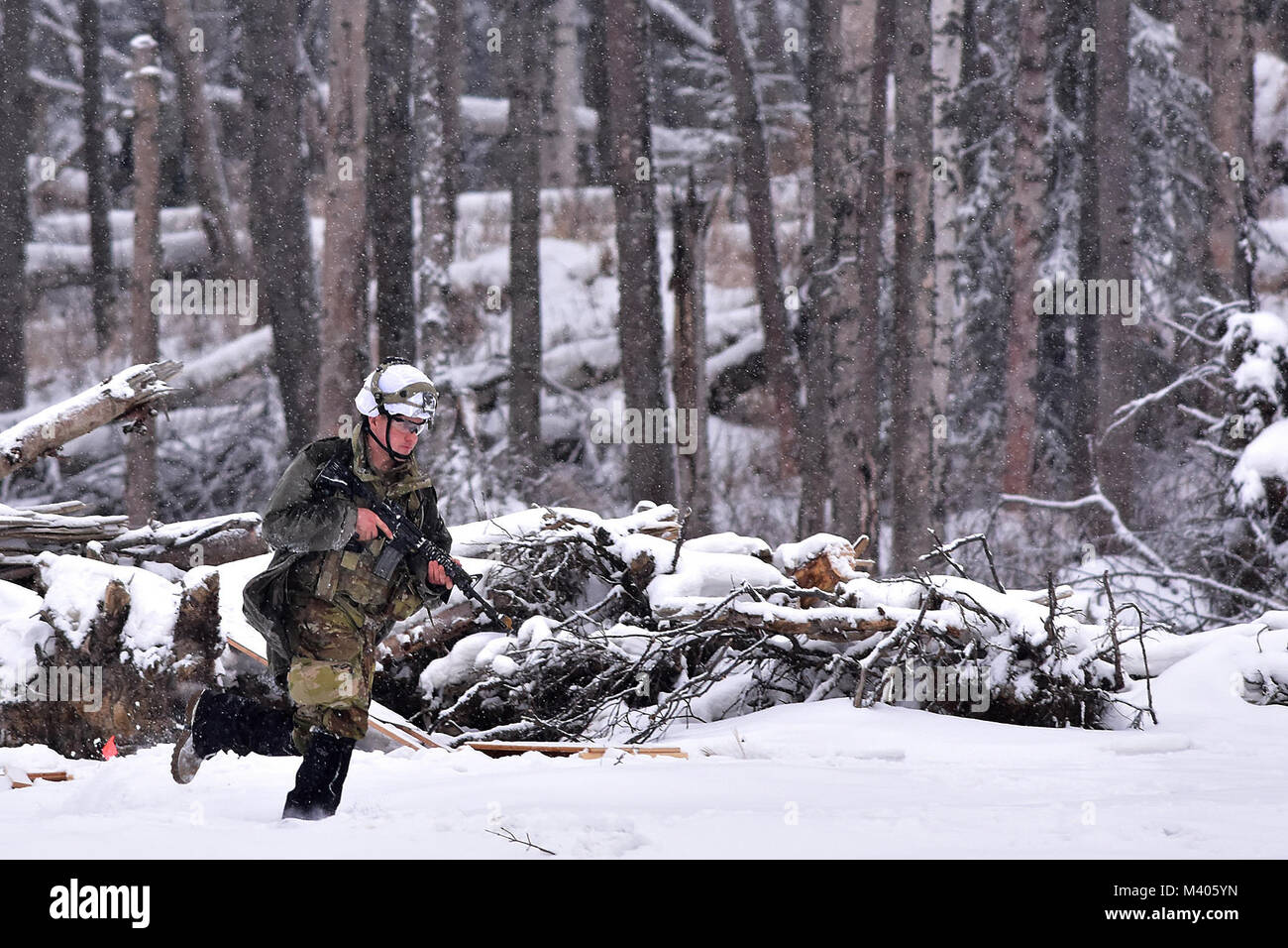 Eine entgegengesetzte Kraft Soldat huscht für den eingehenden B-Company, 1.BATAILLON, 5 Infanterie Regiment, 1 Stryker Brigade Combat Team, 25 Infanterie Division Angriff während des Betriebs der Punchbowl, Feb 6, 2018 vorzubereiten, in der Mehrzweck-Training Strecke auf einer gemeinsamen Basis Elmendorf-Richardson. Eine Übung, die kurzfristiger Einsatz übung Arktis Schub, der Punchbowl erlaubt 1-5 Infanterie die Gelegenheit für ein Bataillon kombinierte Waffen live-fire Übung auf JBER reicht, fast 350 Kilometer von zu Hause entfernt am Fort Wainwright zu trainieren. (Armee Foto/John pennell) Stockfoto