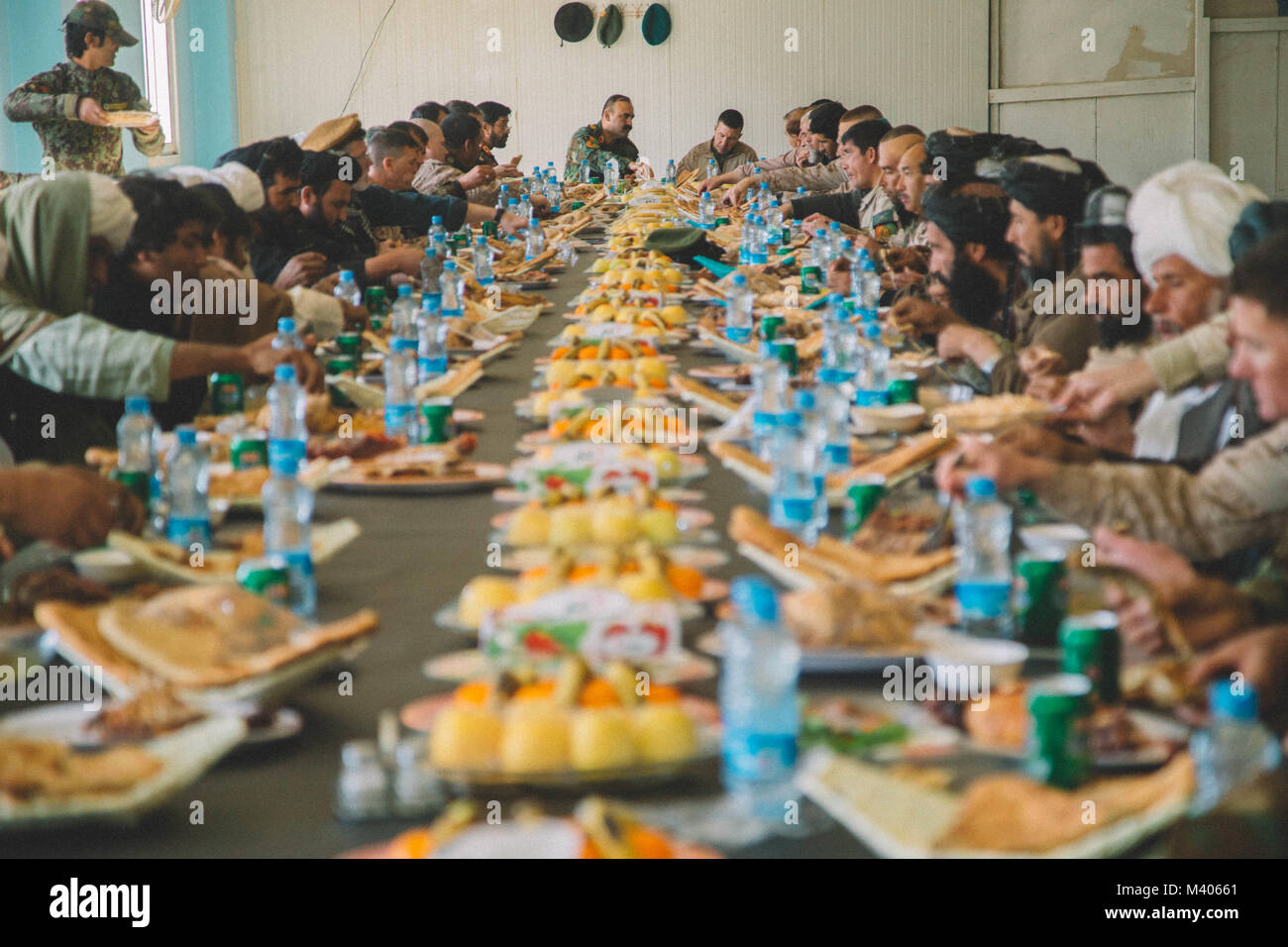 Die örtlichen Ältesten aus Delaram teilen sich ein Essen vorbereitet, die von der afghanischen nationalen Verteidigung und Sicherheit Kraft (ANDSF) mit Verantwortlichen aus dem Task Force (Südwest) (TFSW) am Lager Delaram, Afghanistan Feb 5, 2018. Führungskräfte aus TFSW und die ANDSF führte eine Sicherheit shura zu einem besseren Verständnis der Sicherheitslage durch die örtlichen Ältesten von nimroz Provinz zu gewinnen. (U.S. Marine Corps Foto von Sgt. Conner Robbins) Stockfoto