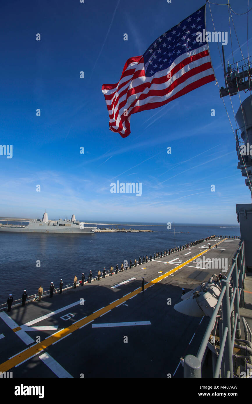 Us-Marines und Matrosen mit dem 26 Marine Expeditionary Unit (MEU) an Bord der Amphibisches Schiff USS Iwo Jima (LHD7) die Schienen Mann während der Abfahrt Naval Station Mayport, Fla., Nov. 7, 2018. Die 26. MEU ist die Teilnahme an einem Einsatz auf See see- und friedenserhaltende Maßnahmen durchzuführen, sowie die Pflege der Beziehungen zu ausländischen Armeen durch gemeinsame Übungen. (U.S. Marine Corps Foto von Cpl. Jon Sosner) Stockfoto