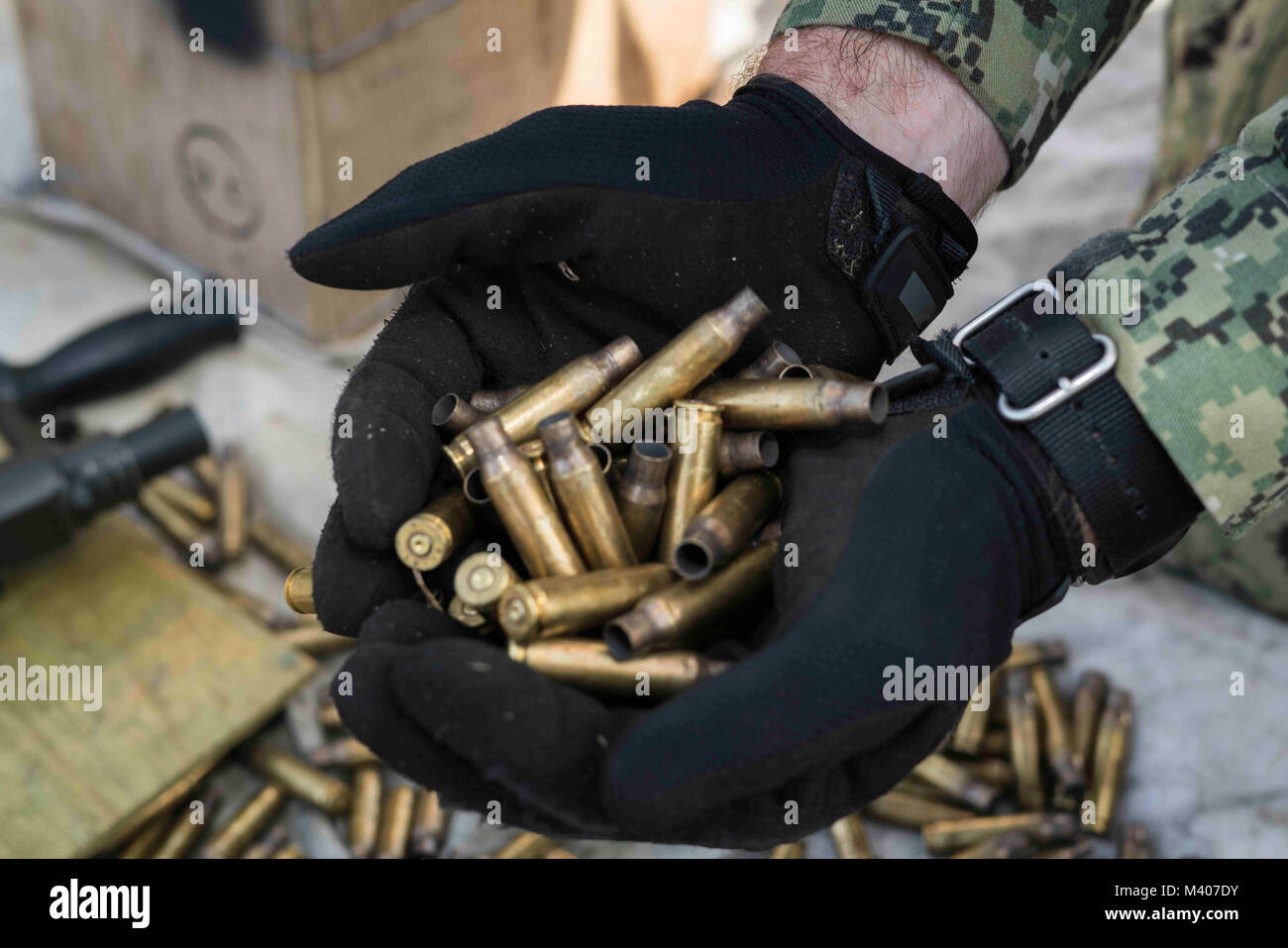 Master-at-Arms 2. Klasse Brendan Morgan, an die in den Küstenzonen Riverine Group (CRG) 1, Det zugeordnet. Guam, nimmt leere Messing Patronen nach einem live-Fire Training am Marinestützpunkt Guam, Feb 7, 2018. Diese vierteljährliche Readiness Training, von der CRG-1 Ausbildungs- und Auswerteeinheit, San Diego gehalten, ermöglicht CRG-1 Det. Guam 360-Punkt Verteidigung, laufende und in-Port an Bord benannten hohen Wert. CRG-1 Det. Guam ist zum Kommandanten, Task Force 75, die primäre Expeditionary task force für die Planung und Ausführung der Küstengebiete Riverine operations, explosive ordnance dis verantwortlich ist Stockfoto