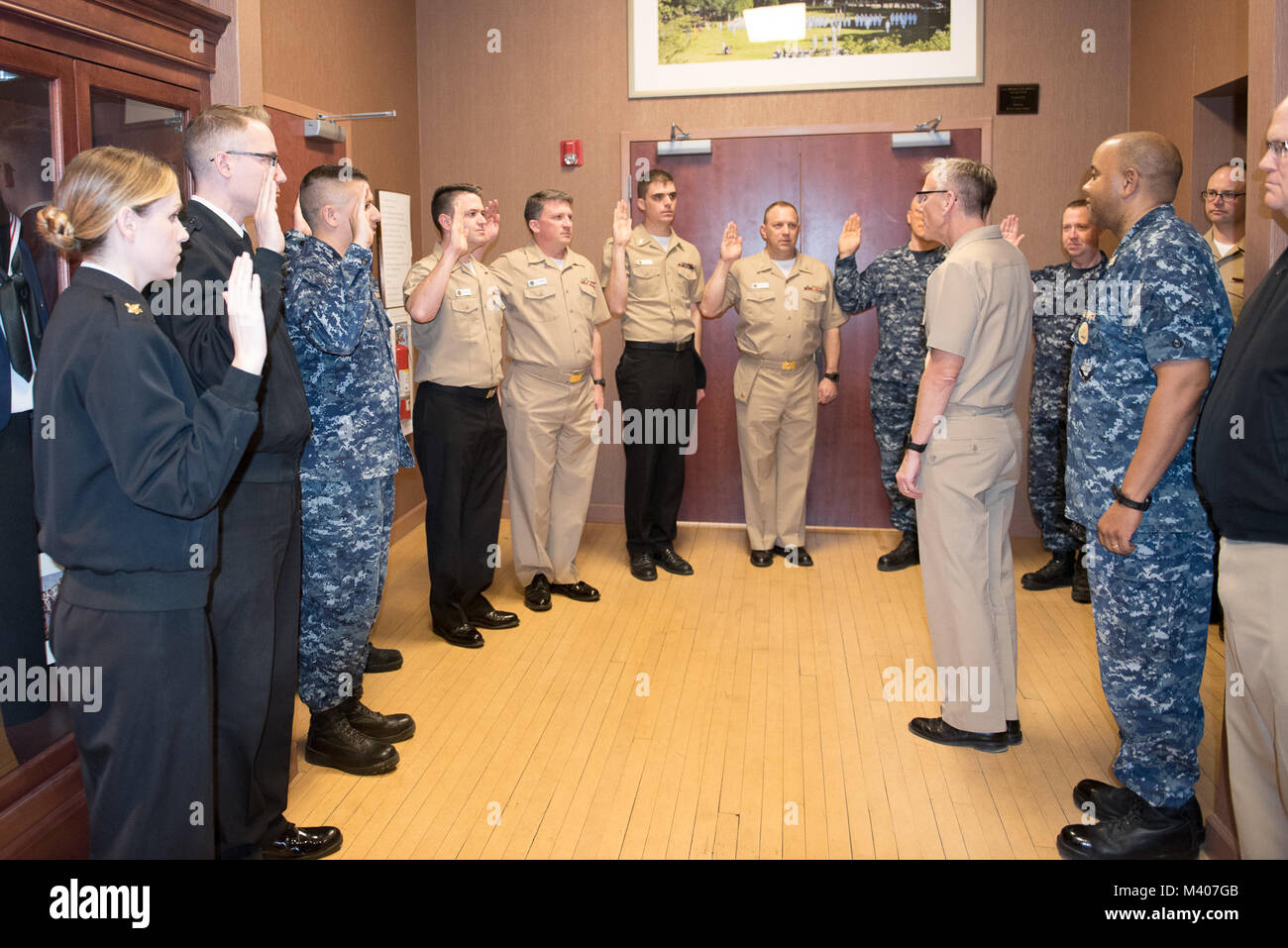 180207-N-ZJ 246-1005 WASHINGTON, DC (Feb. 7, 2018) Kapitän Kenneth Collins, kommandierender Offizier der US-Marine Band, schwört in Mitglieder der U.S. Navy Band mit einem reenlistment Zeremonie im historischen Sail Loft in Washington, DC. (U.S. Marine Foto durch Musiker 1. Klasse Brittany Foster/Freigegeben) Stockfoto