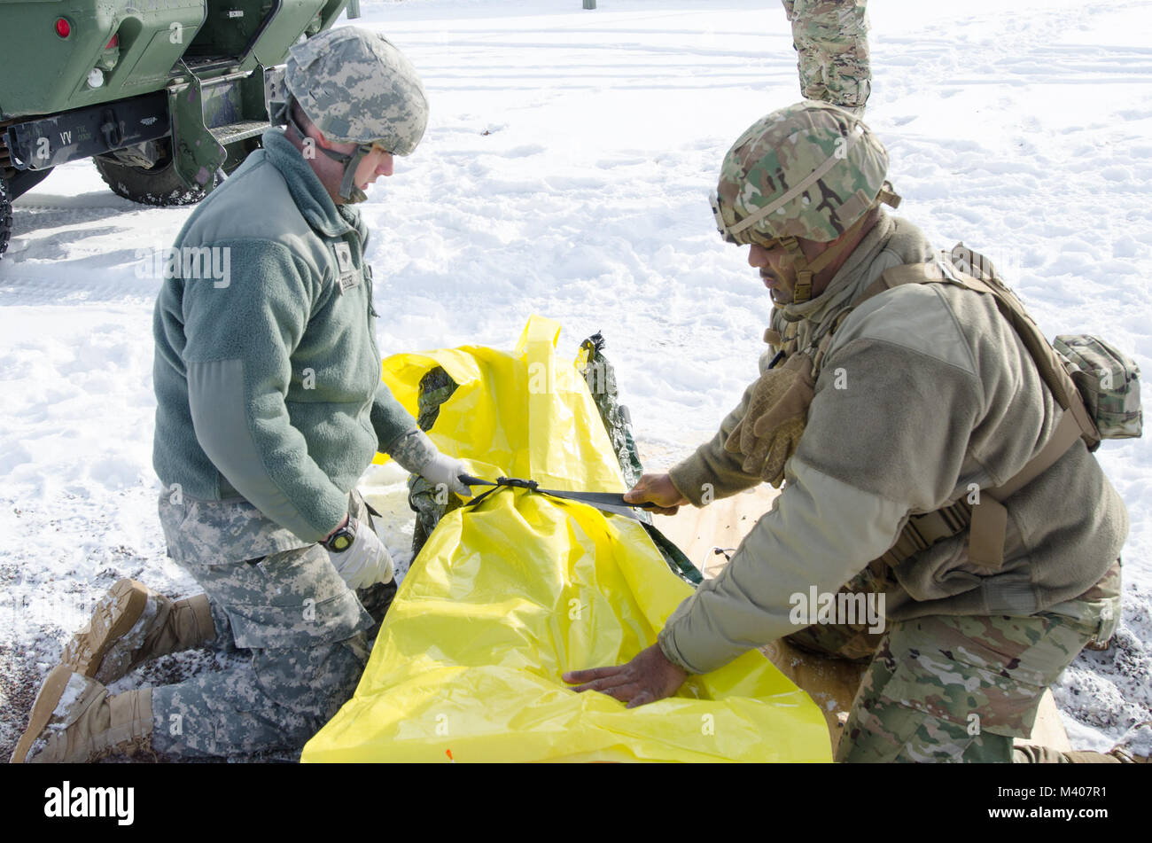 FORT MCCOY, Wis-US Army Reserve Staff Sgt. Javar Manley (rechts) und SPC. Jonathan Hessel, Mediziner, Task Force Triade, Betrieb Cold Steel II, Gurt Notfallpatient Simulator zu einem Wurf, während einer medizinischen Evakuierung Probe am Fort McCoy, Wis., Feb 8, 2018. Betrieb Cold Steel ist der US-Armee finden Crew - Serviert Waffen Qualifizierung und Validierung ausüben, um sicherzustellen, dass America's Army Reserve Einheiten und Soldaten ausgebildet sind und bereit, auf kurze bereitstellen - Bekanntmachung als Teil bereit, Kraft X und Bekämpfung - bereit und tödlichen Feuerkraft zur Unterstützung der Armee und unsere gemeinsamen Partner überall in bringen Stockfoto