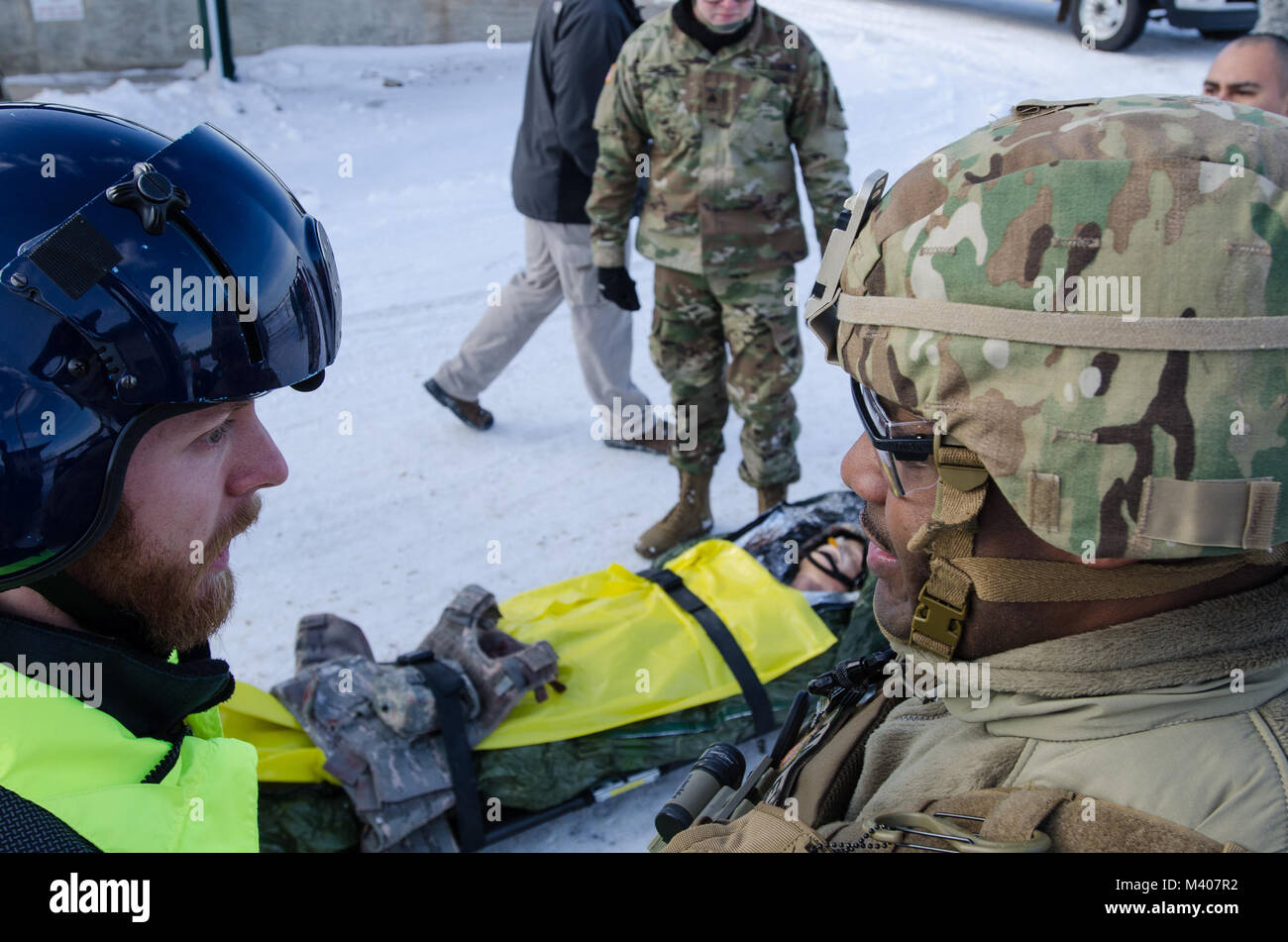 FORT MCCOY, Wis-US Army Reserve Staff Sgt. Javar Manley (rechts), Sanitäter, Task Force Triade, Betrieb Cold Steel II, bespricht der Zustand des Patienten im Notfall Simulator mit der Evakuierung Team während einer medizinischen Evakuierung Probe am Fort McCoy, Wis., Feb 8, 2018. Betrieb Cold Steel ist der US-Armee finden Crew - Serviert Waffen Qualifizierung und Validierung ausüben, um sicherzustellen, dass America's Army Reserve Einheiten und Soldaten ausgebildet sind und bereit, auf kurze bereitstellen - Bekanntmachung als Teil bereit, Kraft X und Bekämpfung - bereit und tödlichen Feuerkraft zur Unterstützung der Armee und unsere gemeinsamen Partner bringen keine Stockfoto