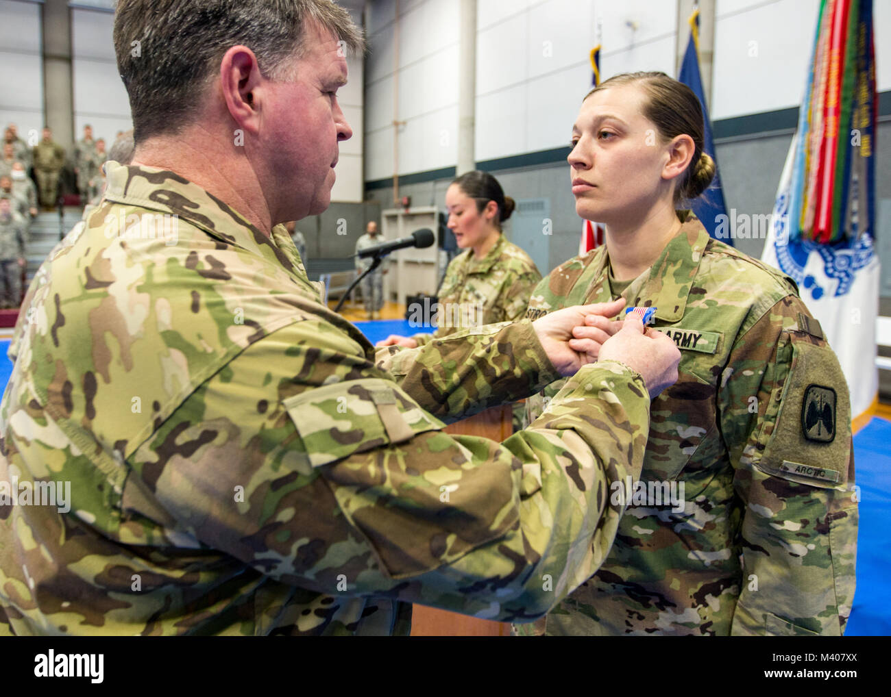 Us-Armee Alaska kommandierender General, Generalmajor Mark O'Neil Pins des Soldaten Medaille auf SPC. Rosalind Stromberg während einer Zeremonie am Fort Wainwright, Alaska, 8. Februar 2018. Spc. Stromberg erhielt die Auszeichnung für das Leben eines Mannes nach einer tödlichen Lawinen in der Nähe von Delta Junction, Alaska am 3. April 2016. Nach der Behandlung der Opfer für Schock und Vermeiden von unterkühlung sie mit ihm für fünf Stunden geblieben, bei Minusgraden bis Notdienste angekommen. (U.S. Armee Foto: Staff Sgt. Sean Brady) Stockfoto