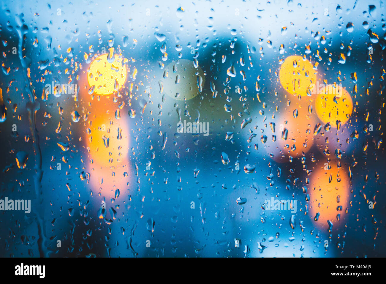 Regen fällt auf Fenster. Ruhigen Abend oder in der Nacht zu Hause, wenn draussen geregnet. Wassertropfen auf Glas. Oberfläche der nassen Glas. Wasser spritzen. City lights Bo Stockfoto