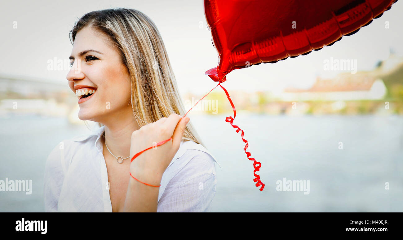 Girl posiert im Freien im Sommer mit bunten Luftballons Stockfoto