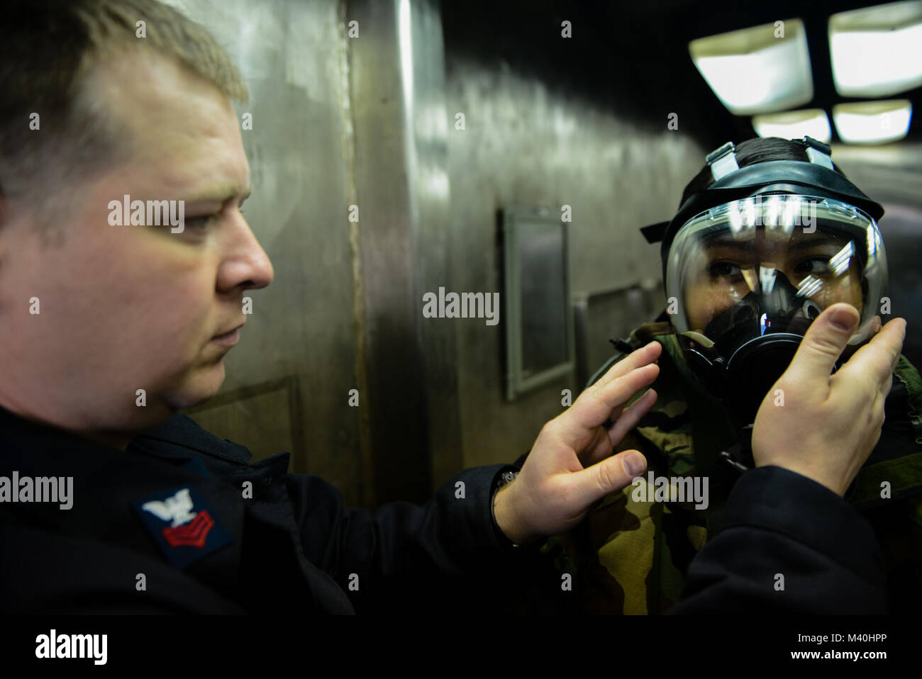 150416-N-TC 437-012 PAZIFISCHER OZEAN (16 April 2015) - Aviation Machinist Mate 1. Klasse James Newman, von Augusta, Ga., prüft Airman Karina Brito, von Norwalk, Anschl, MCU-2/P Gas mask für eine ordnungsgemäße Dichtung während der chemischen, biologischen und radiologischen warfare Training an Bord der USS John C Stennis (CVN 74). Stennis befindet sich in der maßgeschneiderten Ausbildung an Land, die Verfügbarkeit und die endgültigen Entwicklung Problem, die Bewertung ihrer Fähigkeiten Kampfeinsätze zu führen, unterstützen Funktionen und komplexe Unfall Kontrolle Situationen überleben. (U.S. Marine Foto von Mass Communication Specialist 3. Klasse D. Ignacio Perez/Freigegeben Stockfoto